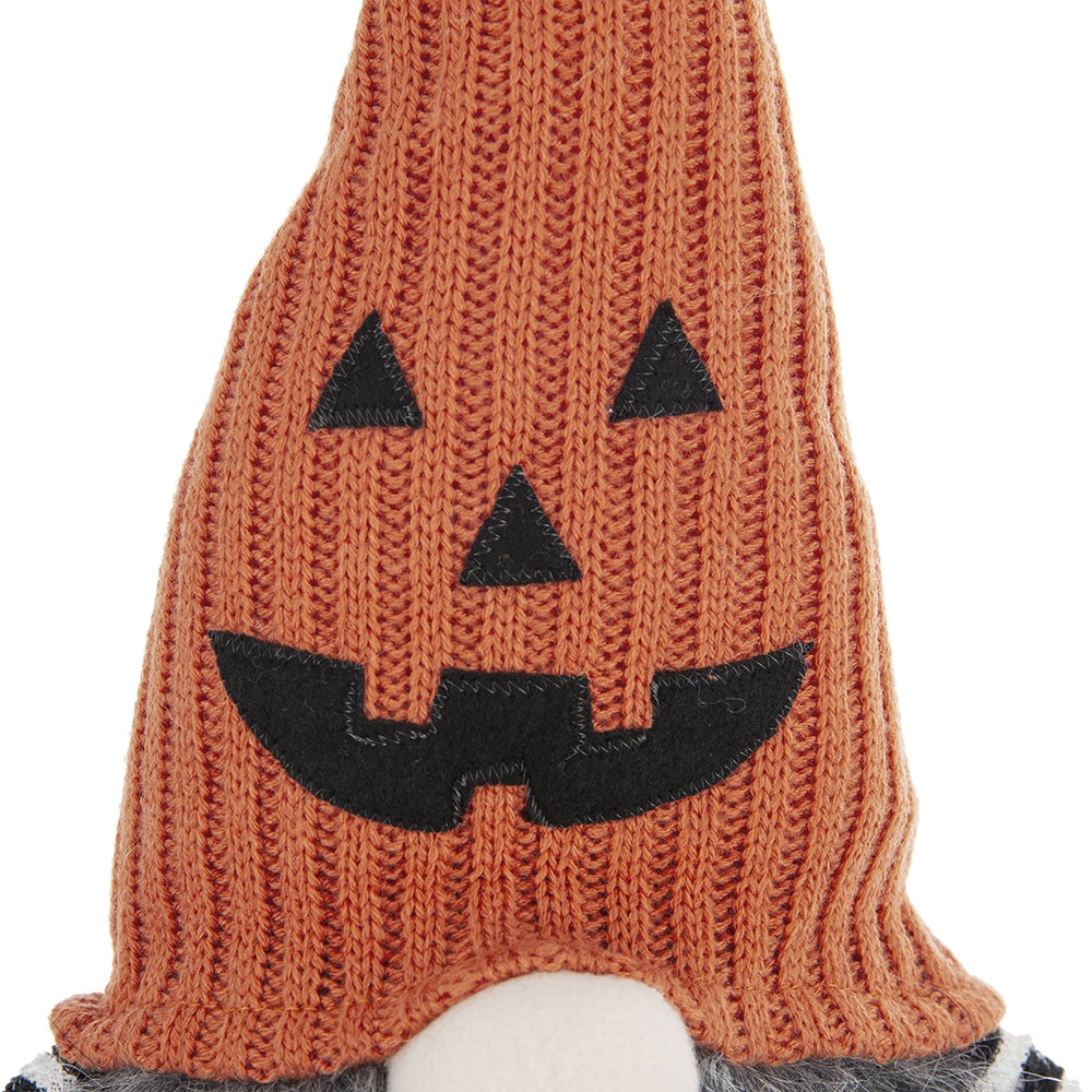 Orange knitted gnome with a carved jackolantern face perfect for Halloween decor