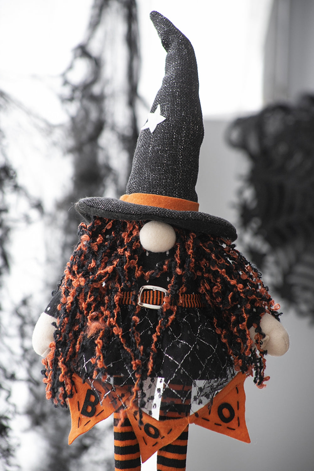 Halloween gnome with black witch hat orange and black shaggy hair and striped legs