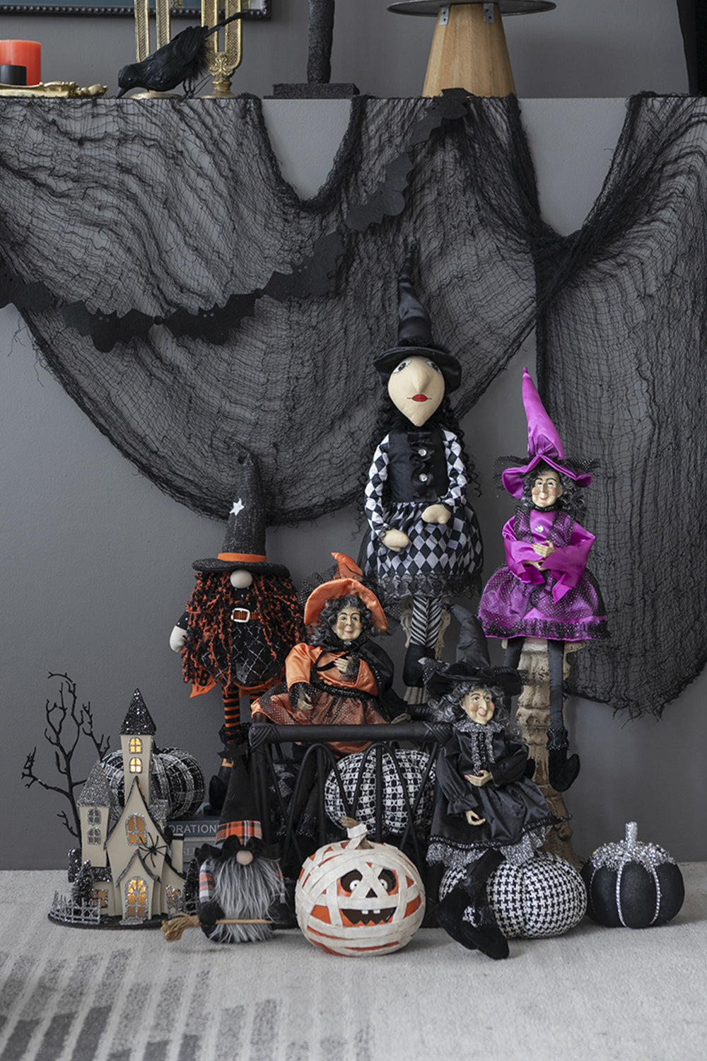Group of whimsical Halloween witch figures and spooky decorations