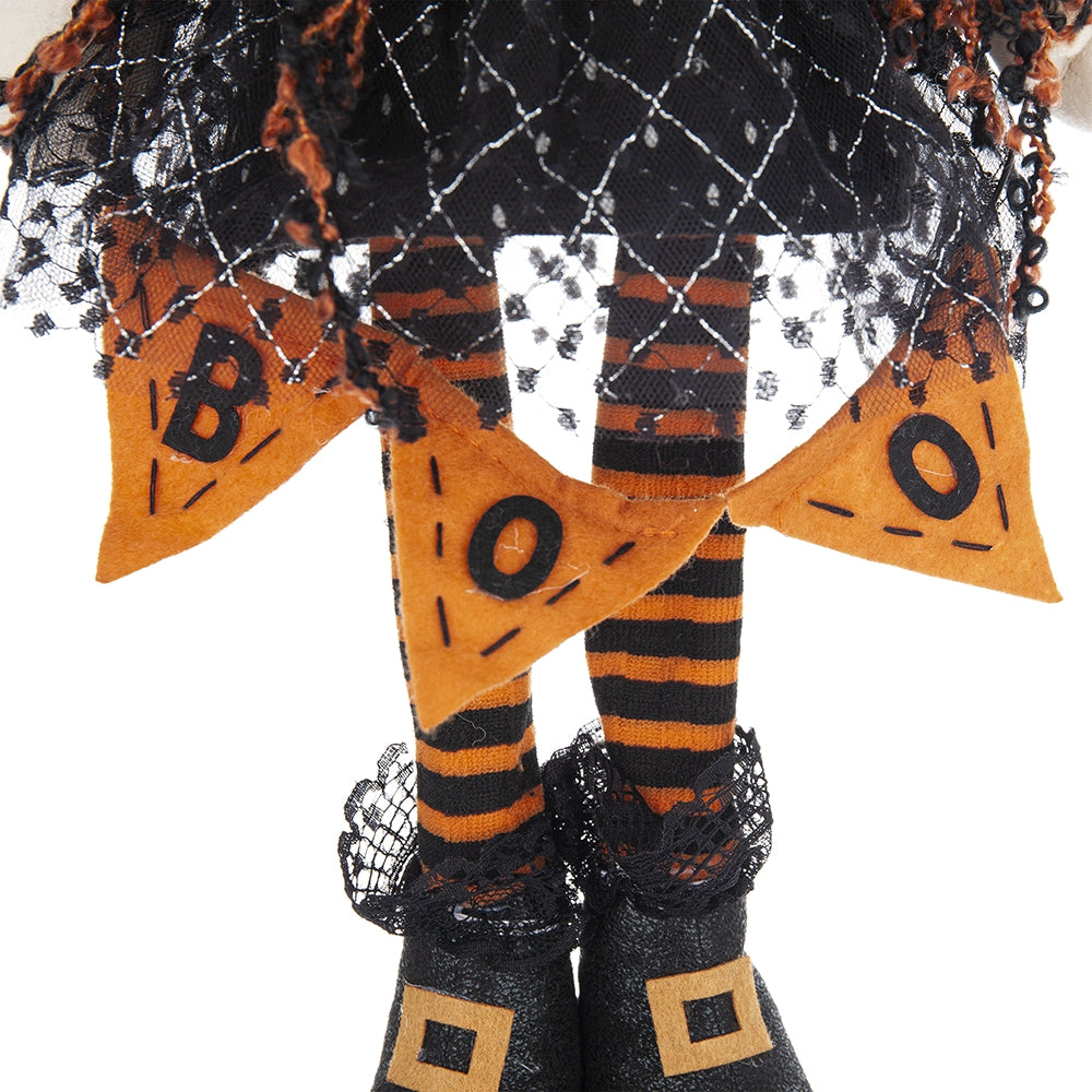 Closeup of Halloween witch legs with black and orange stripes black boots and a BOO banner