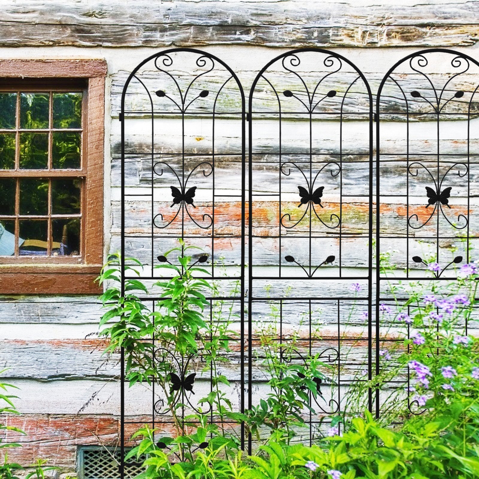 Black metal garden trellis with ornate scrollwork and butterfly accents ideal for climbing plants