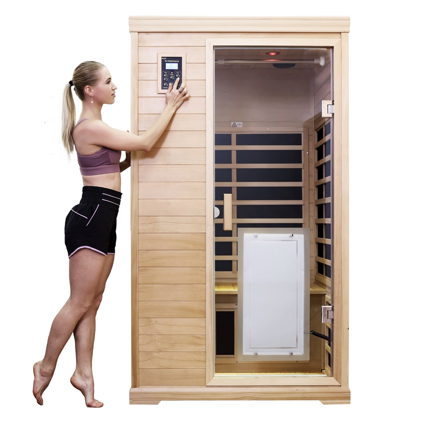 Young woman adjusting controls on a wooden far infrared sauna with glass door