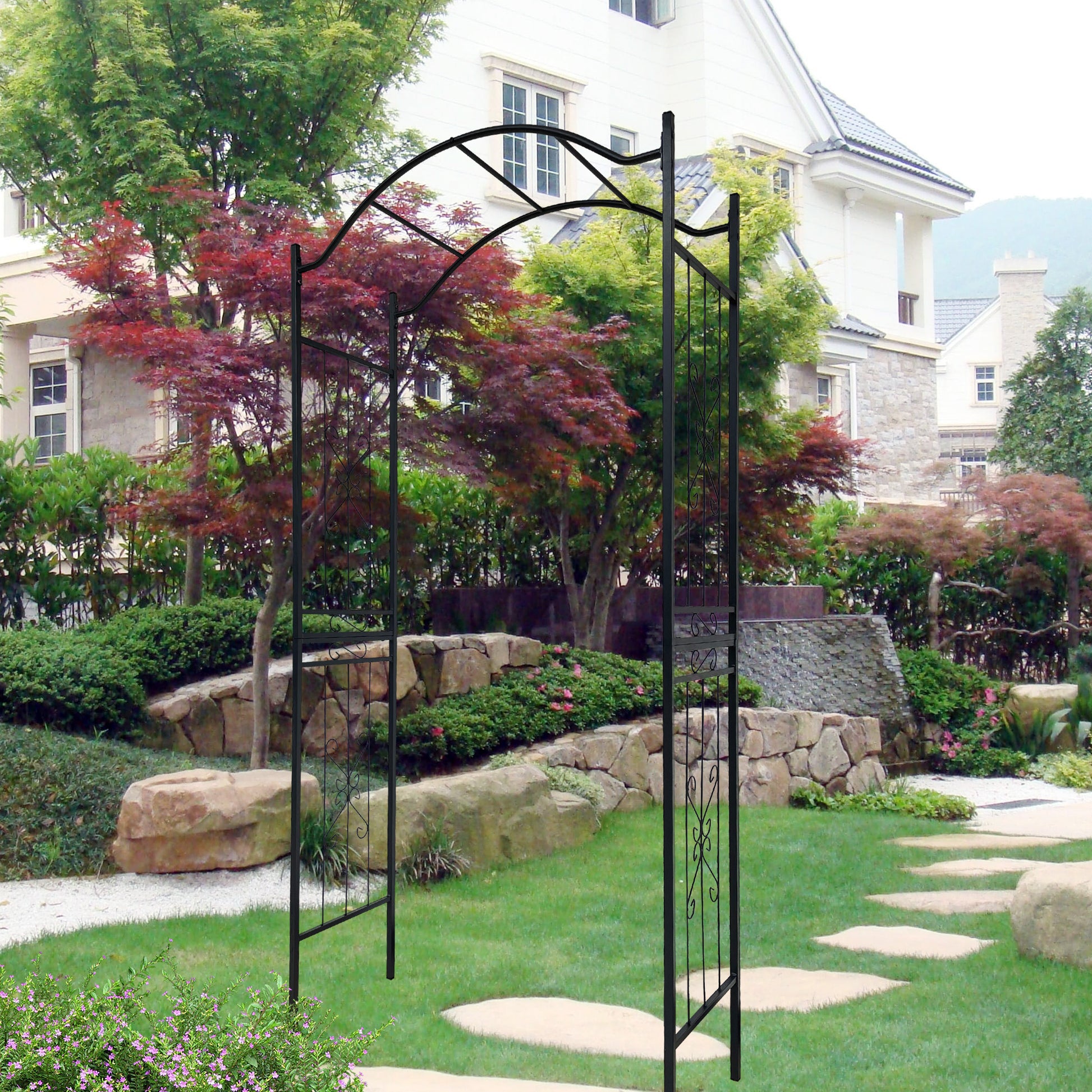 Black metal garden arch with scrollwork gate enhancing outdoor landscaping