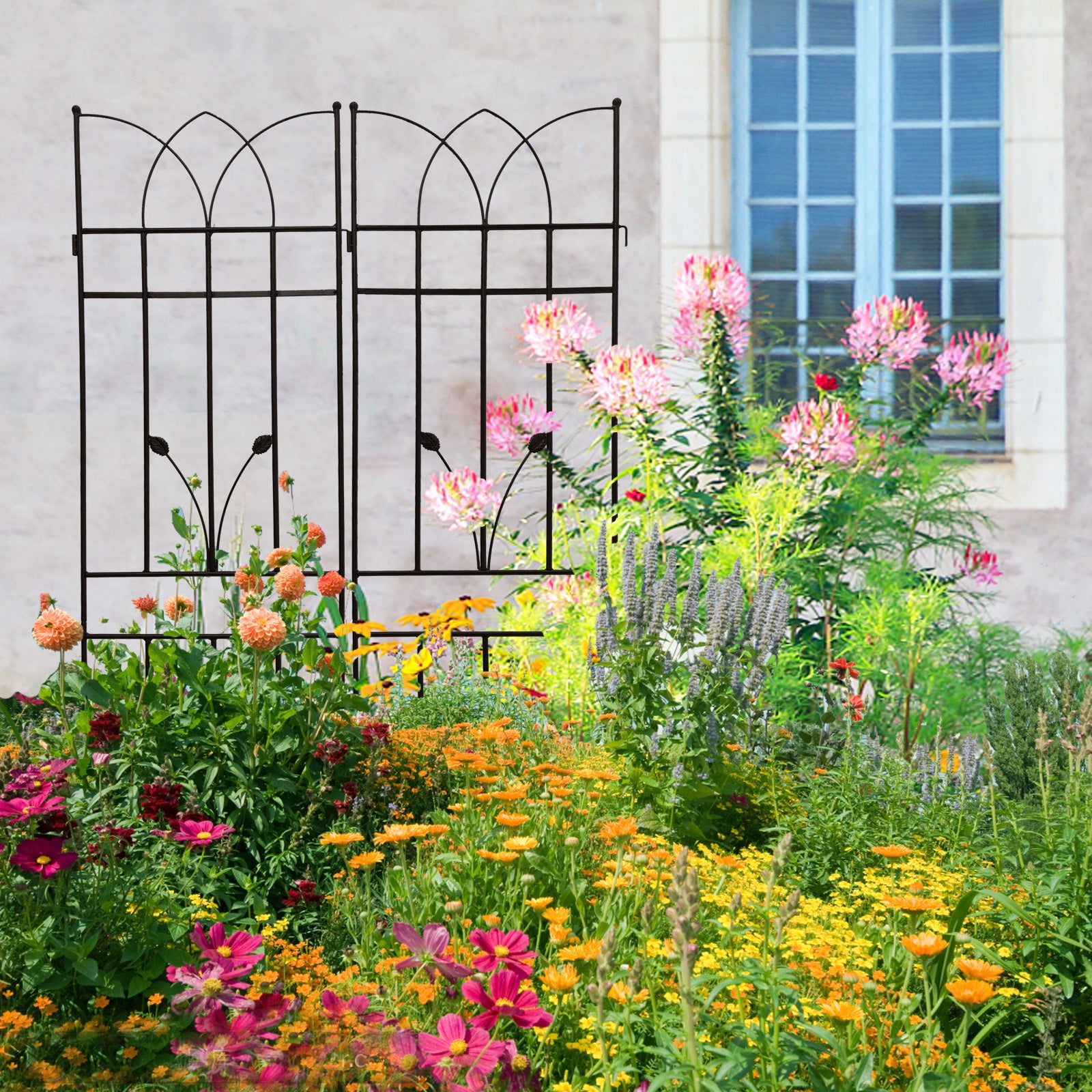 Black metal garden trellis with ornate arched top supporting climbing plants and vibrant flowers