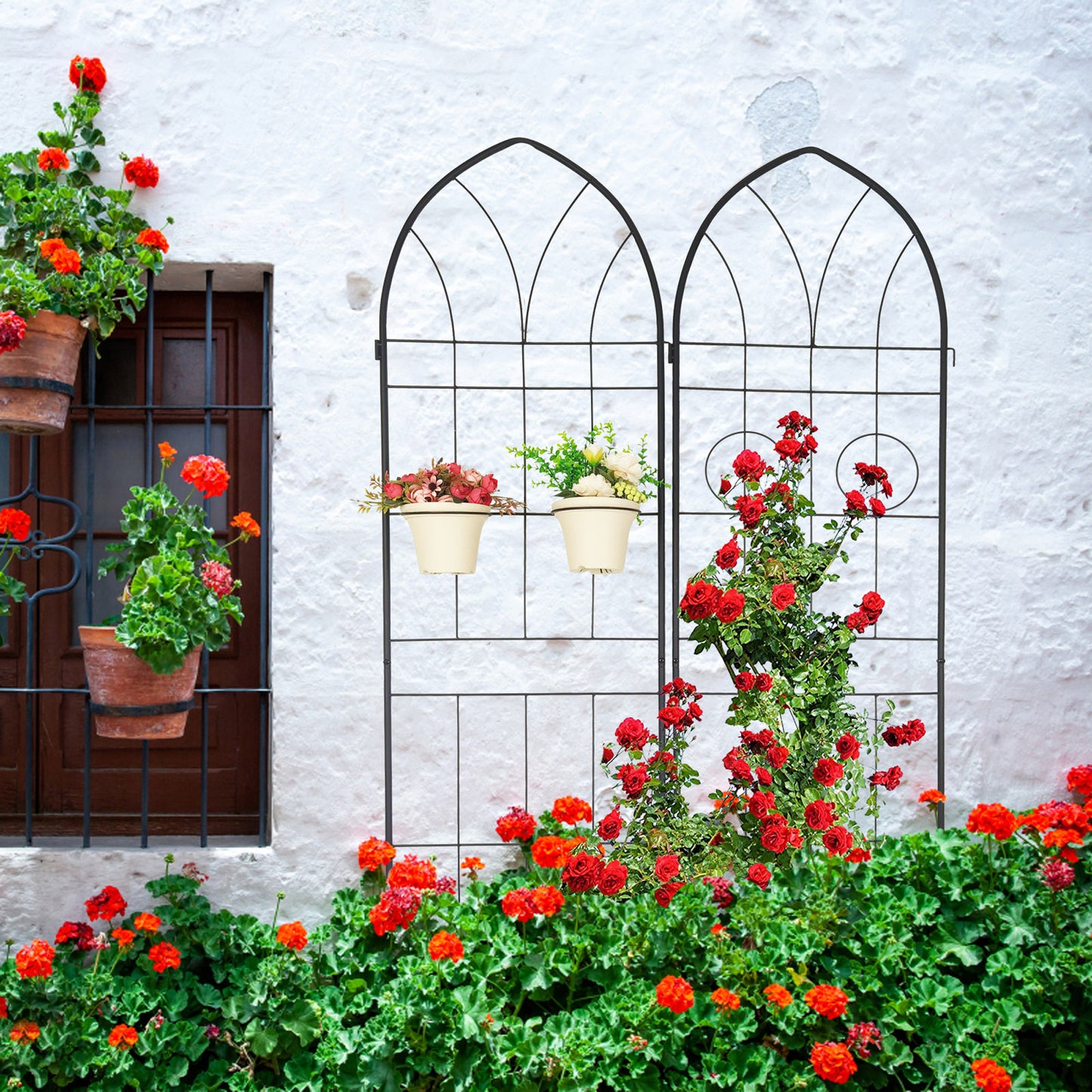Black metal arched garden trellis with climbing red roses