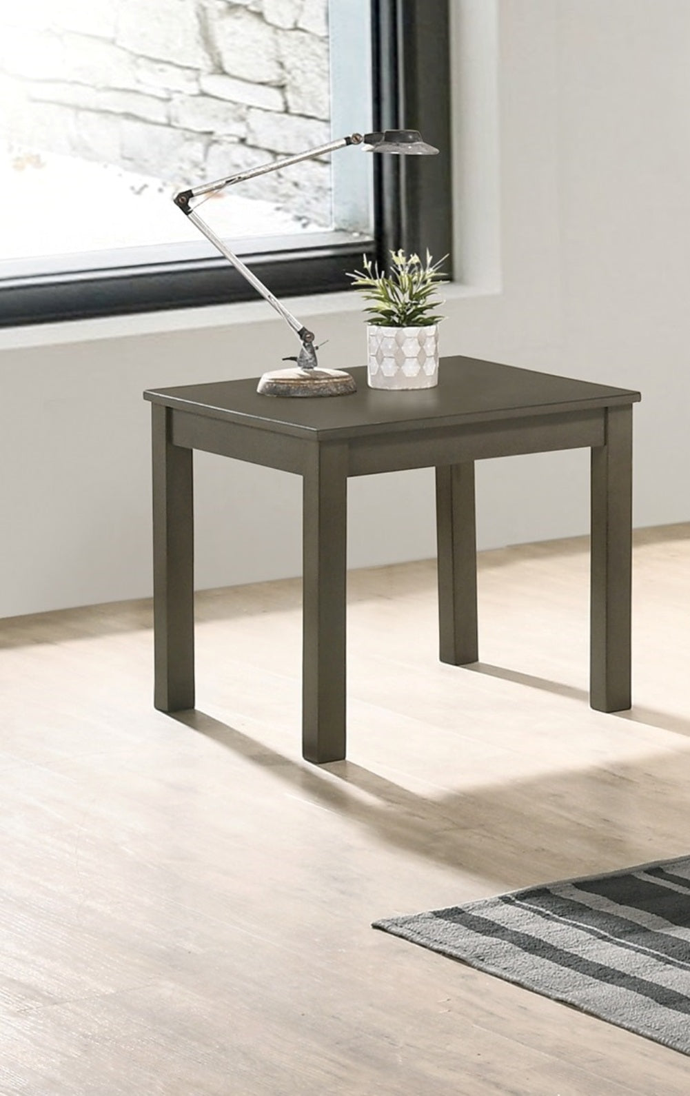 Square grey end table with modern lamp and potted plant