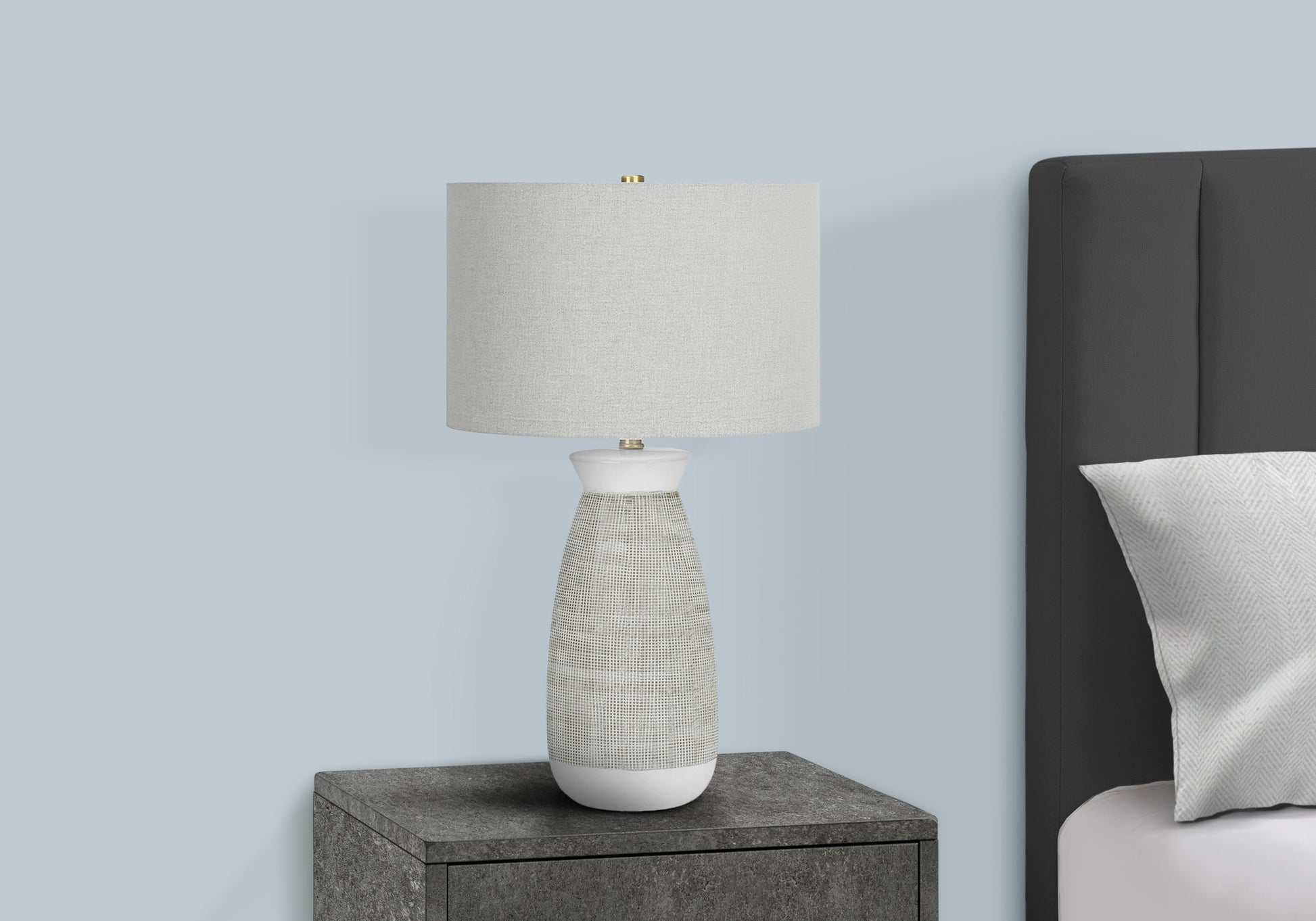 Modern bedside table lamp with textured white ceramic base and linen shade