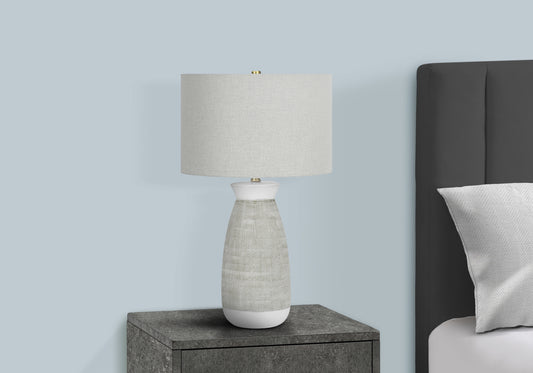 Modern bedside table lamp with textured white ceramic base and linen shade