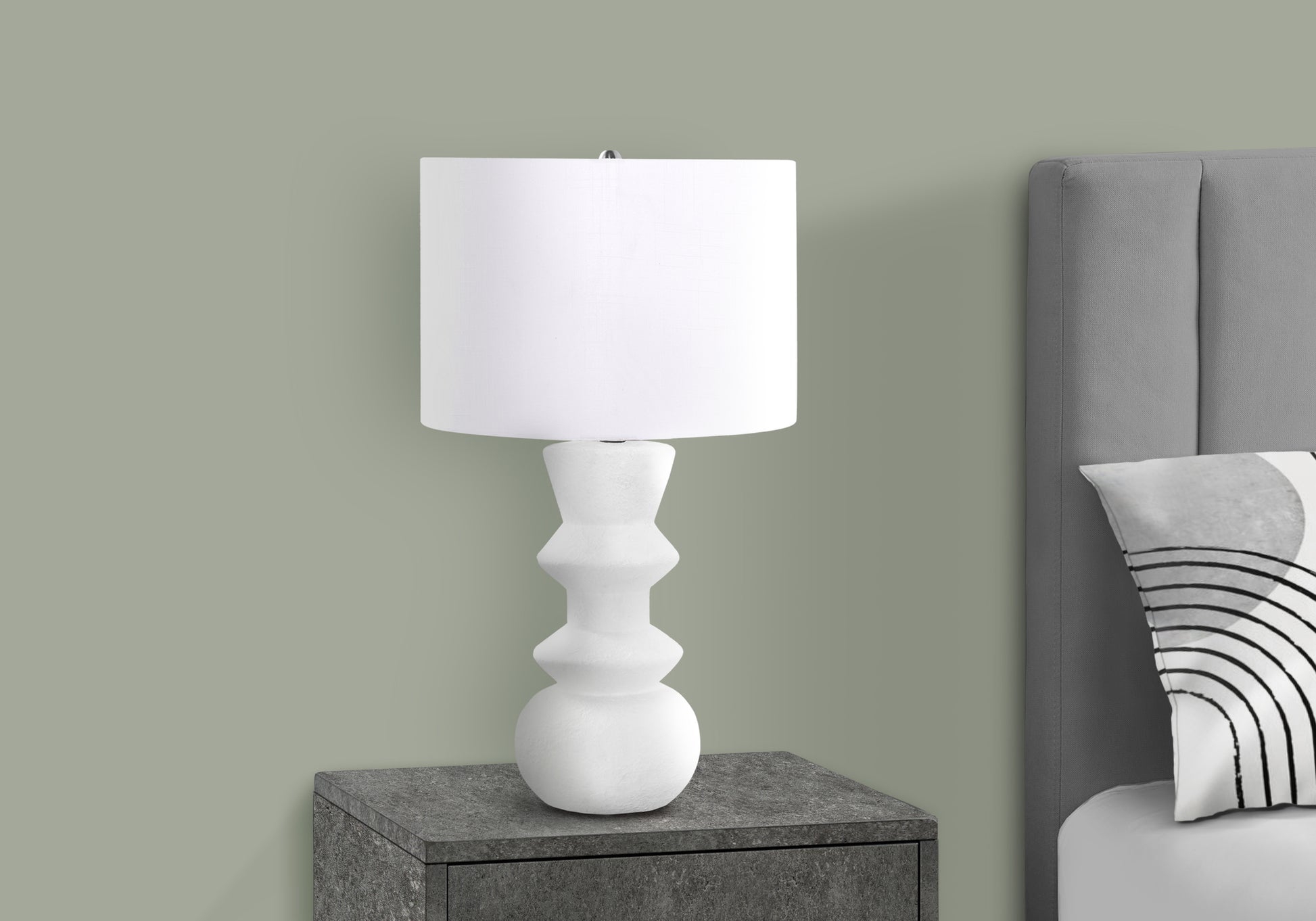 White textured modern table lamp with drum shade on gray nightstand