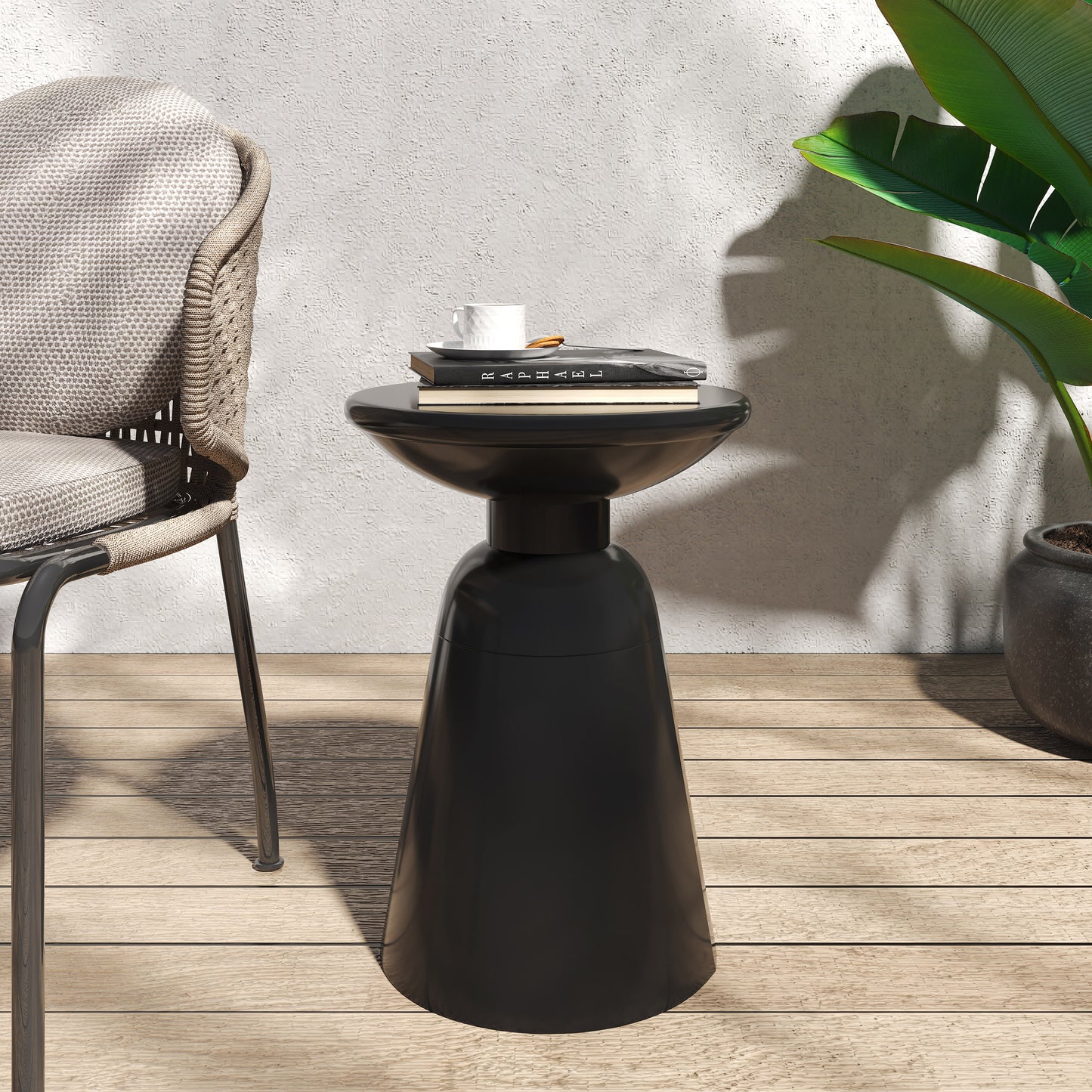 Modern black hourglass side table with books and coffee cup