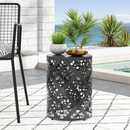 Round metal side table with abstract cutouts perfect for patio use