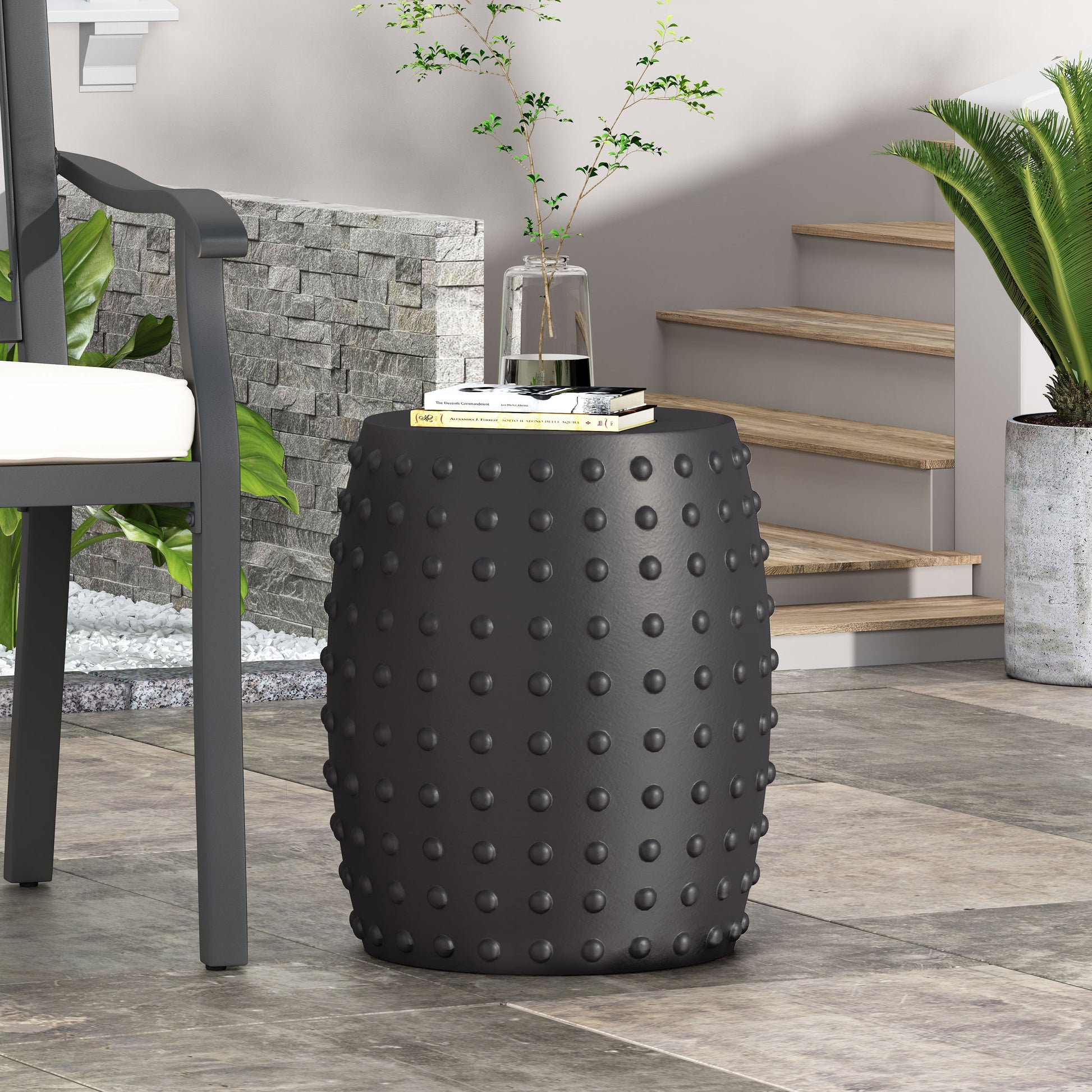 Black ceramic garden stool with raised stud texture and classic drum shape