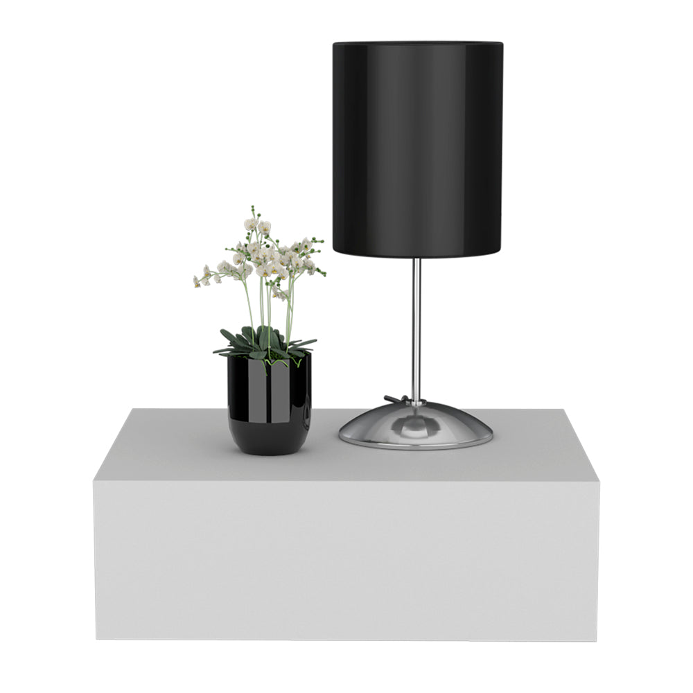 Modern black cylinder table lamp with a sleek silver base and a small potted orchid