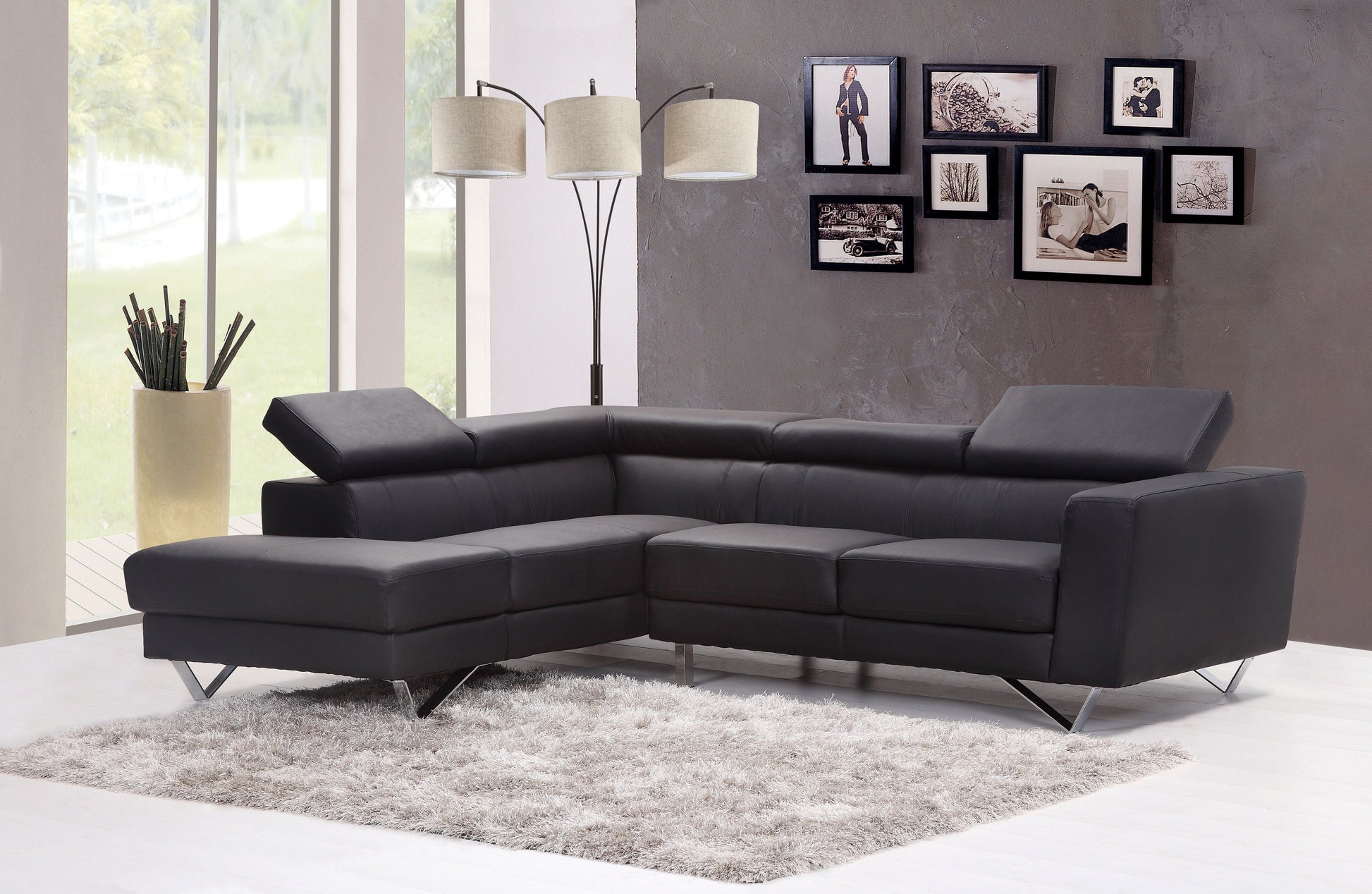 Dark gray leather sectional sofa with chrome legs on a plush rug