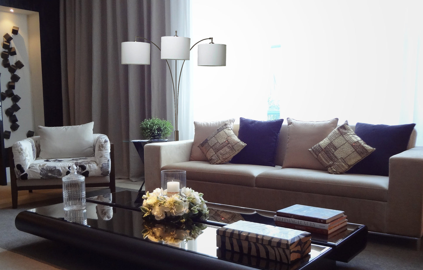 A modern tan sofa with decorative throw pillows and a floor lamp in a living room setting