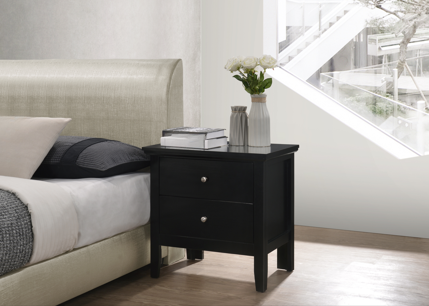 Black twodrawer nightstand with silver knobs on a wooden floor