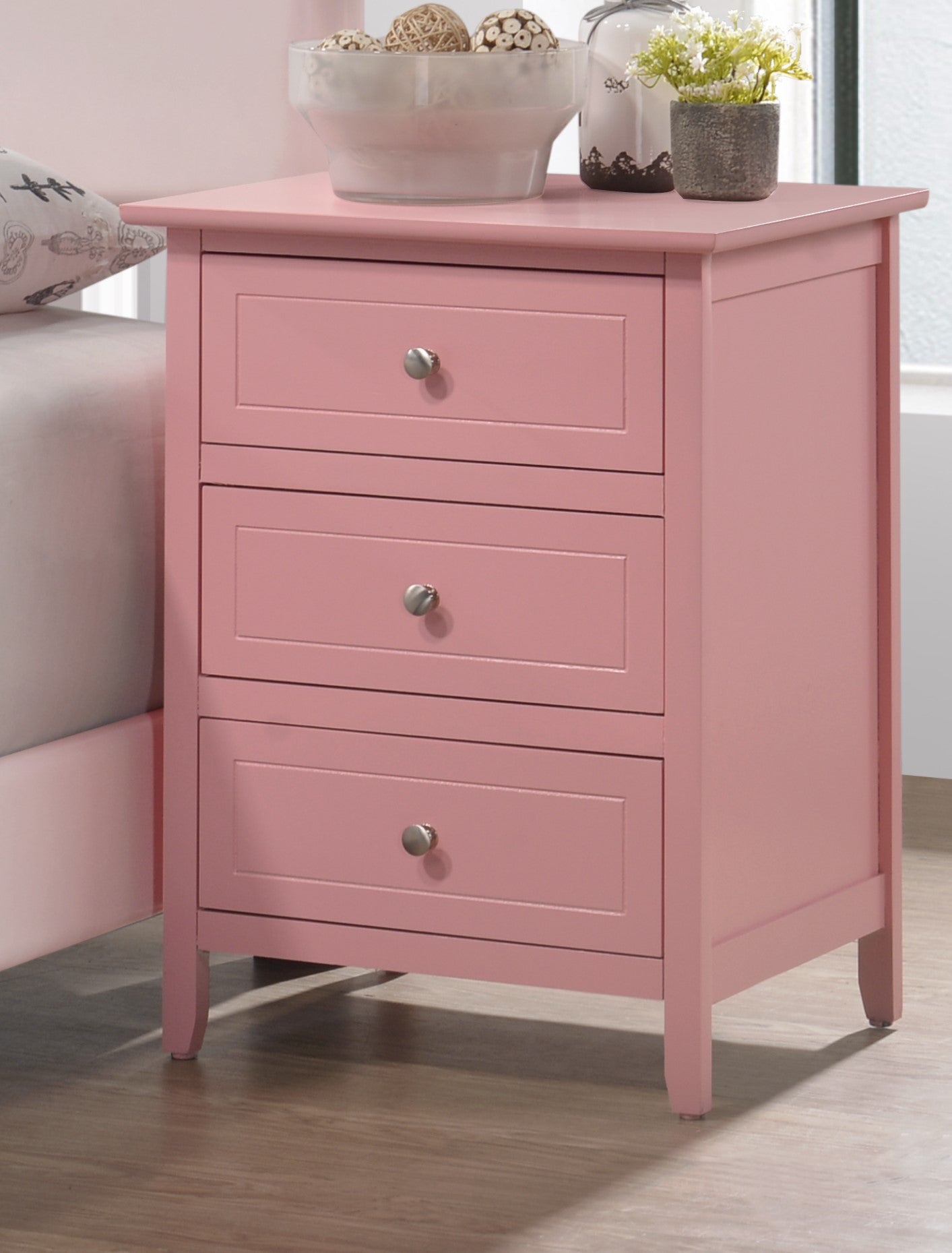 Pink wooden nightstand with three drawers and silver knobs