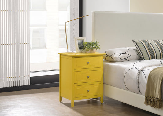 Yellow wooden nightstand with three drawers and silver knobs by a bed