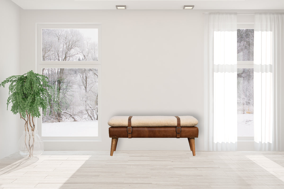 Brown leather bench with sheepskin cushion and buckle straps