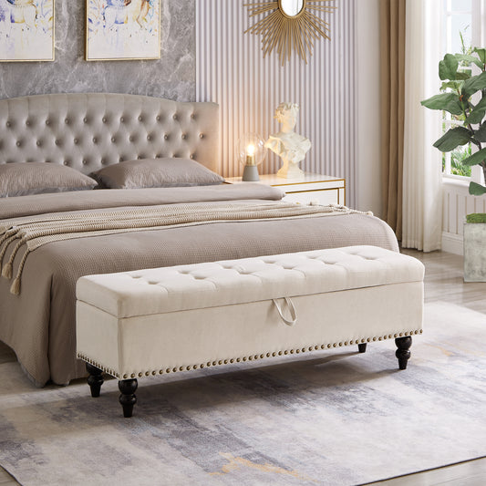 Tufted beige storage ottoman with nailhead trim and dark wooden legs