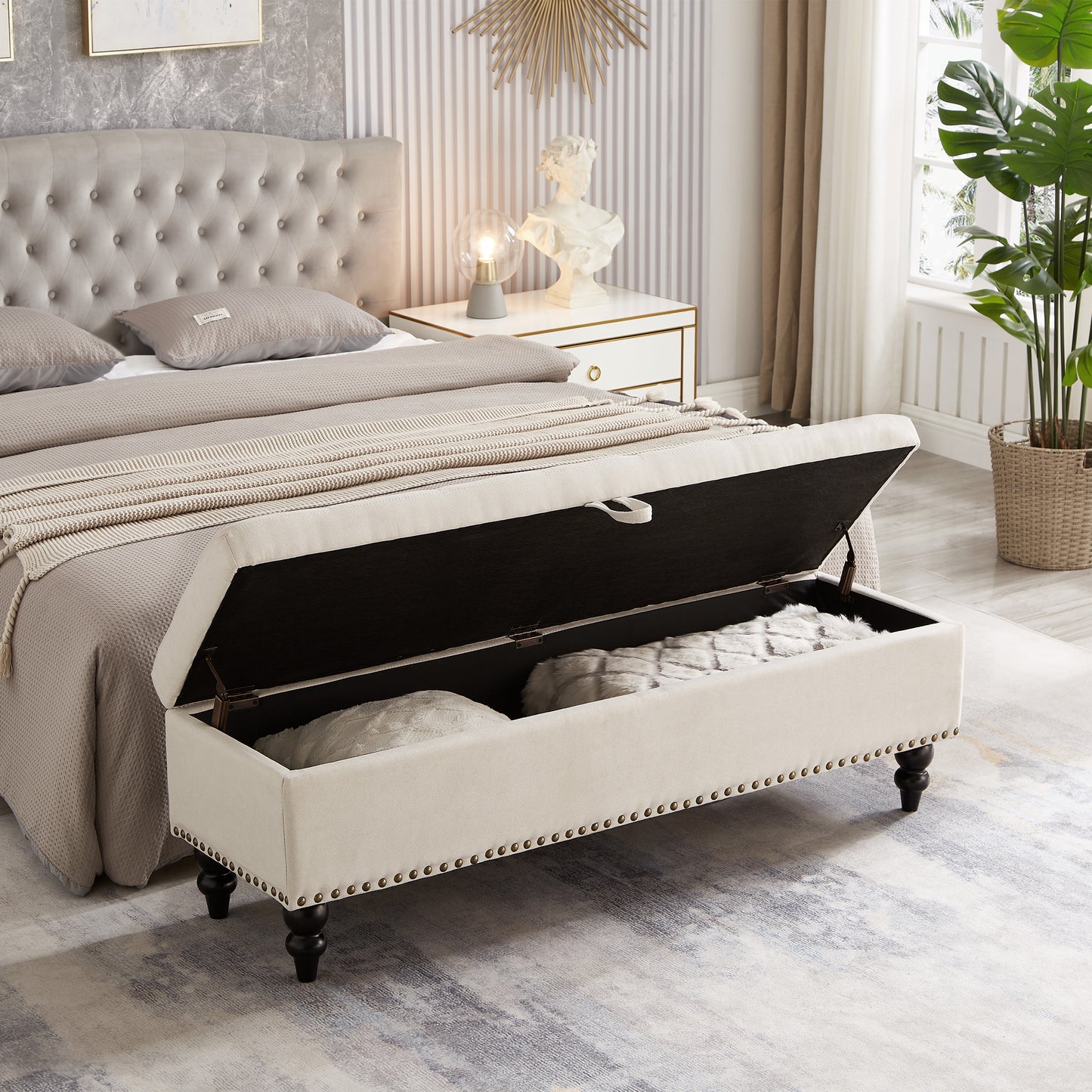 Cream tufted storage bench with bronze nailhead trim open to reveal storage