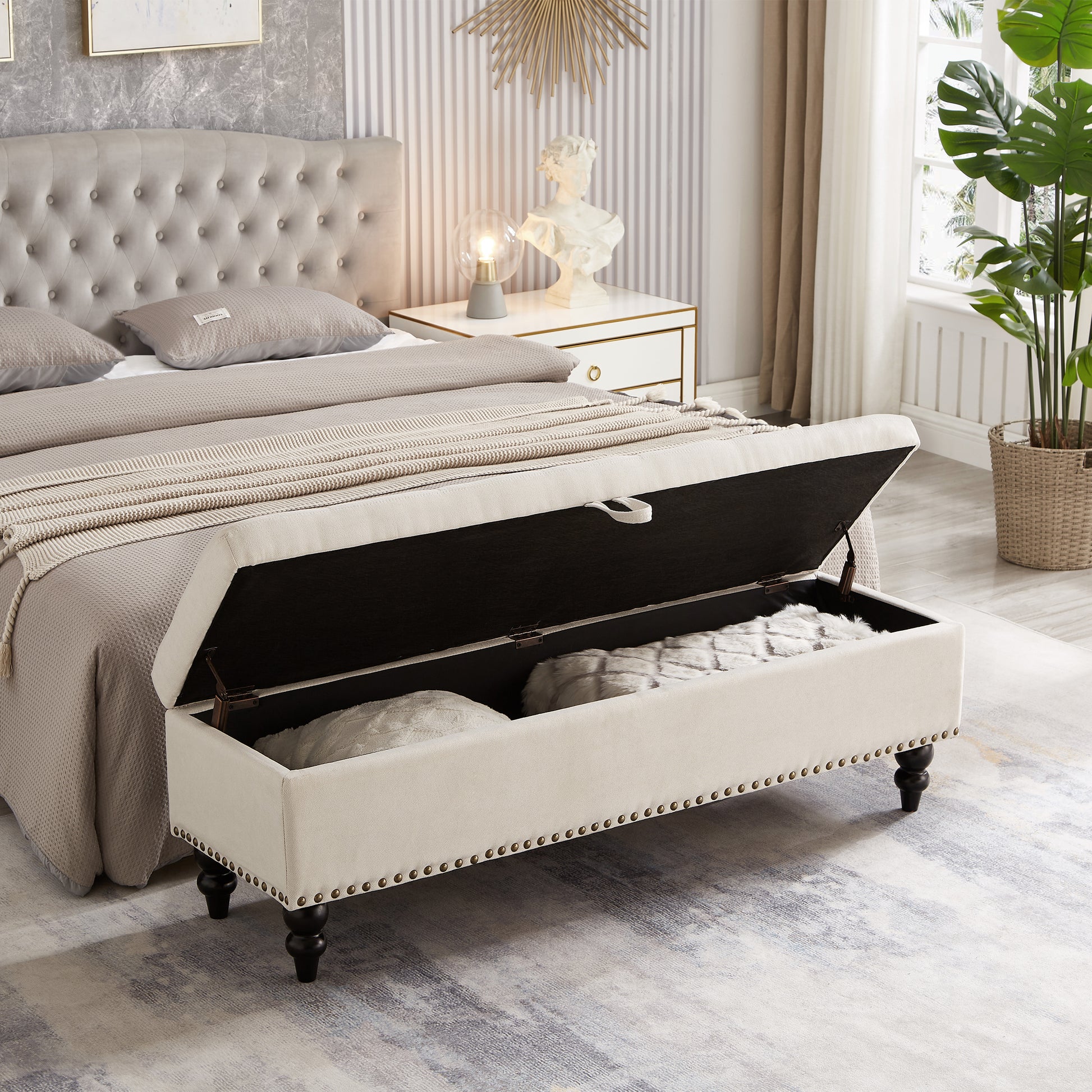 Cream tufted storage bench with bronze nailhead trim open to reveal storage