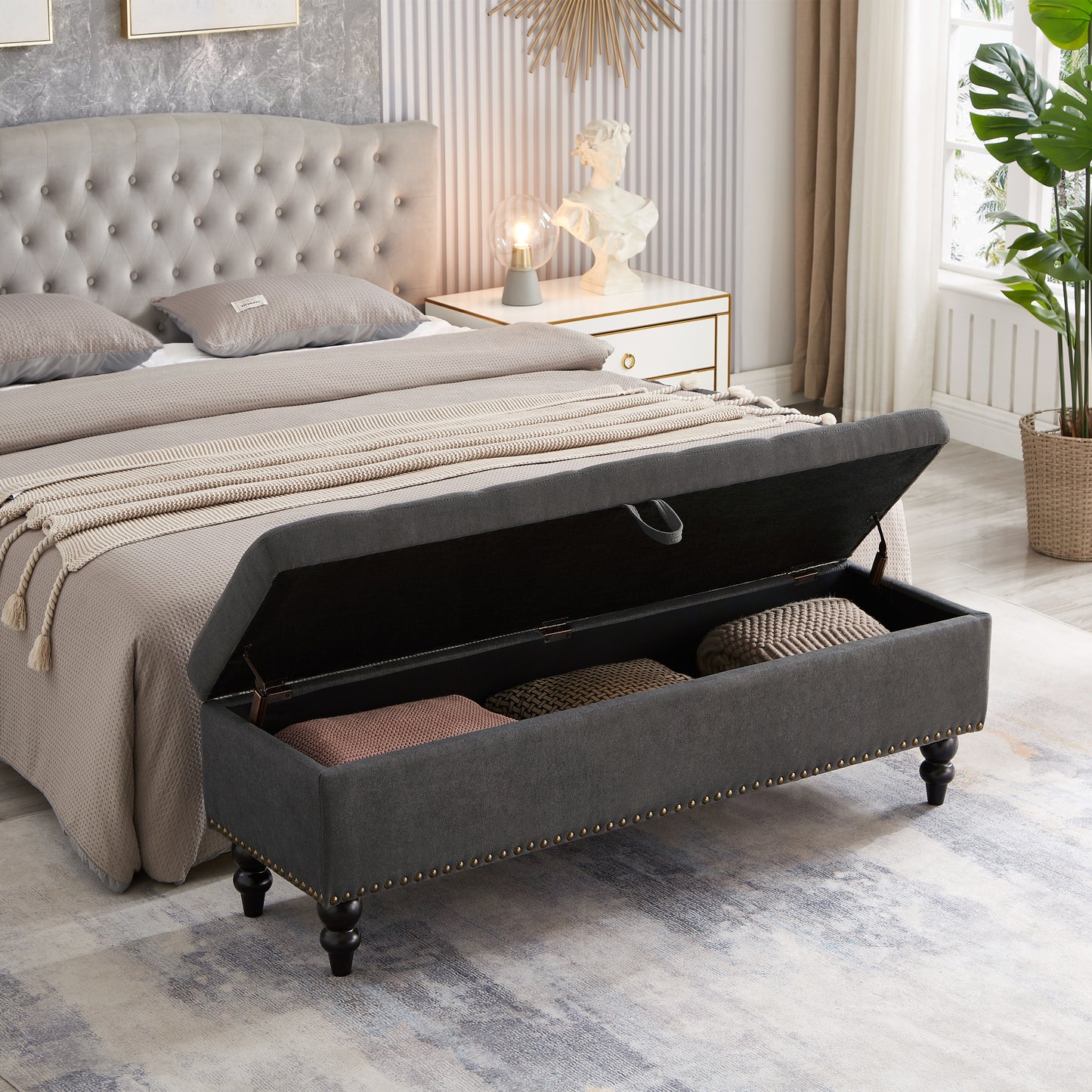 Dark gray upholstered storage bench with tufted detailing and gold studs