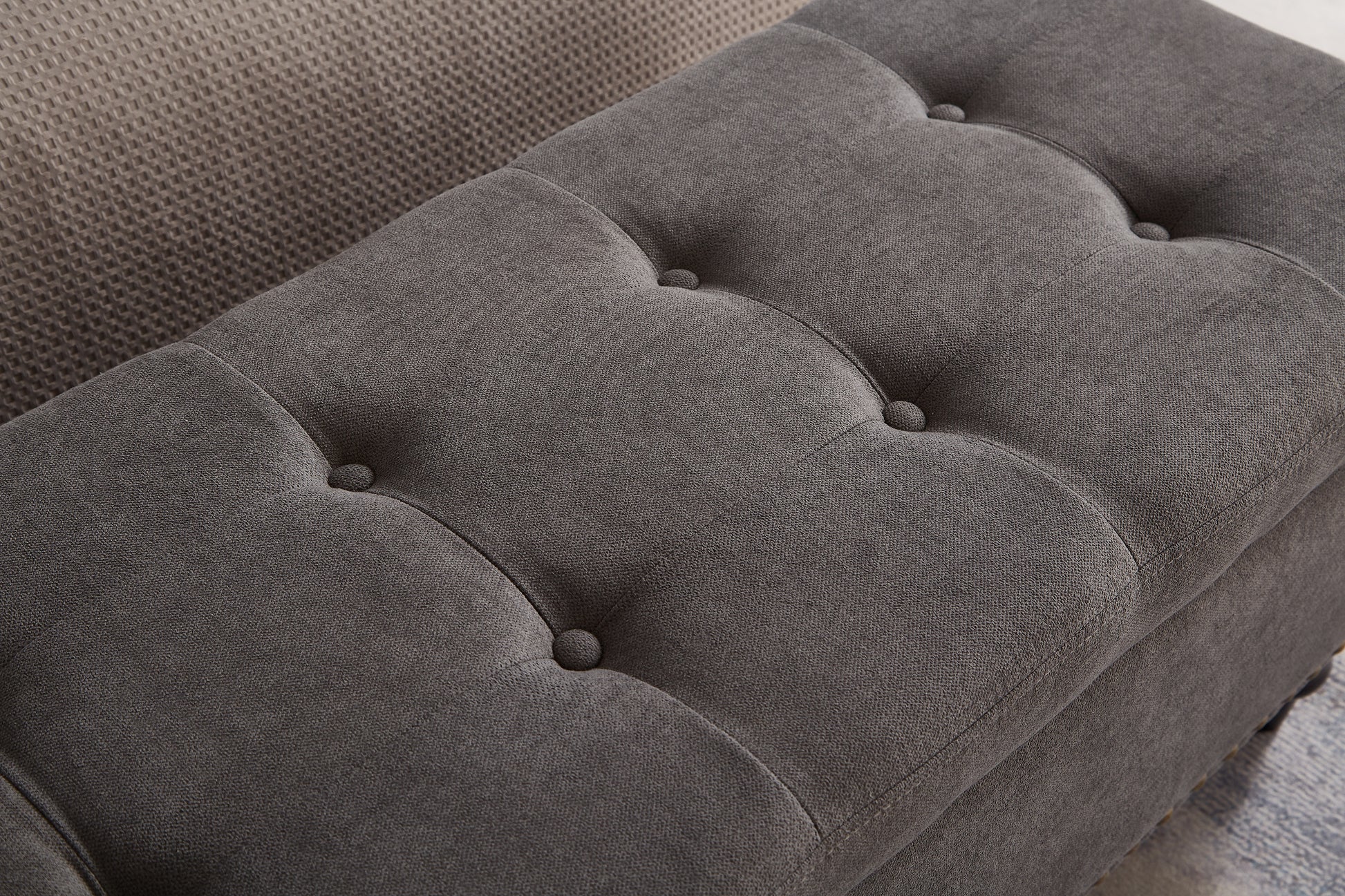 Dark grey fabric storage ottoman with button tufting