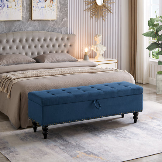 Navy blue tufted storage bench with gold nailhead trim and dark wood legs