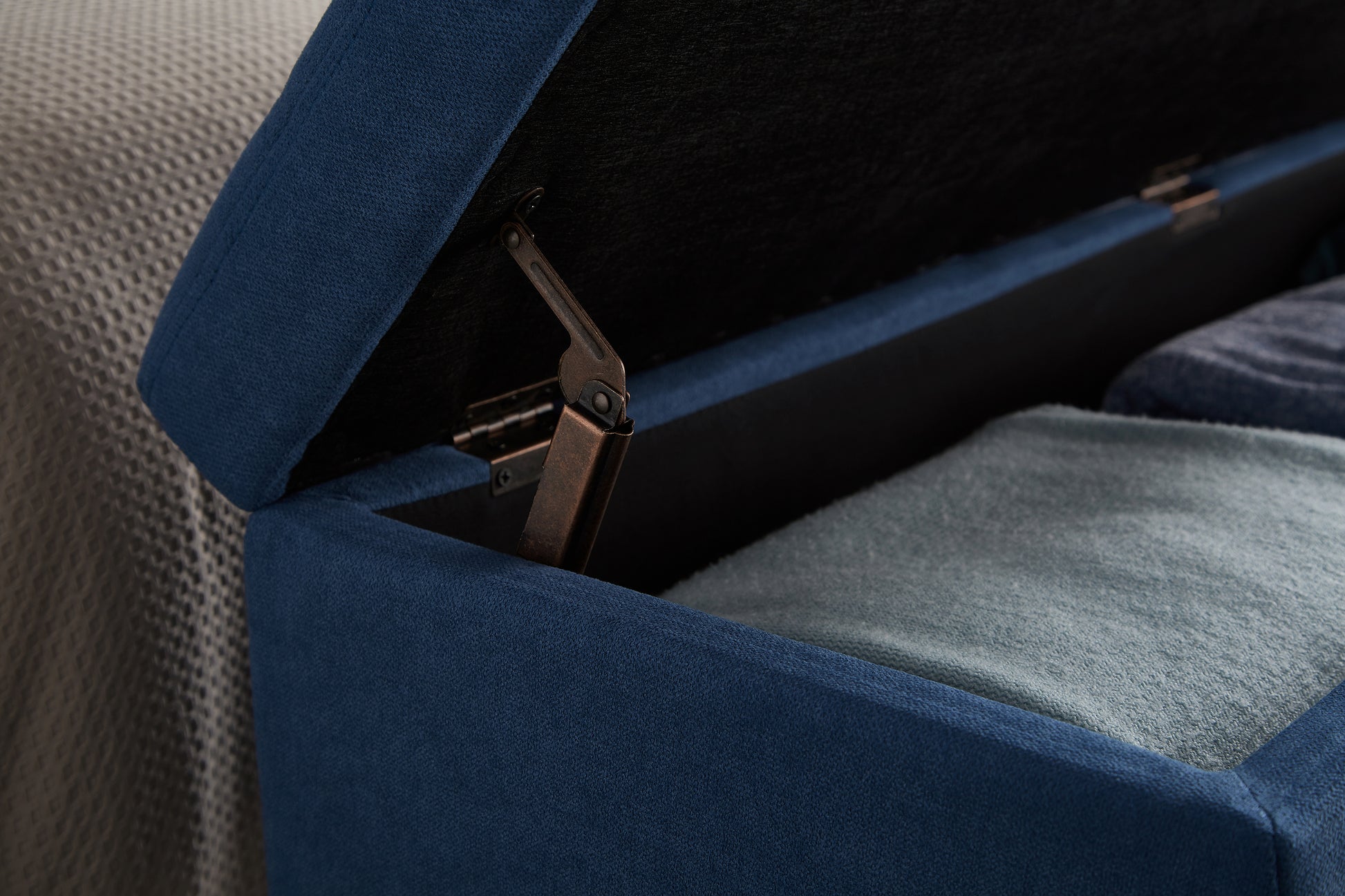 Navy blue ottoman storage unit with textured fabric and metal hinge