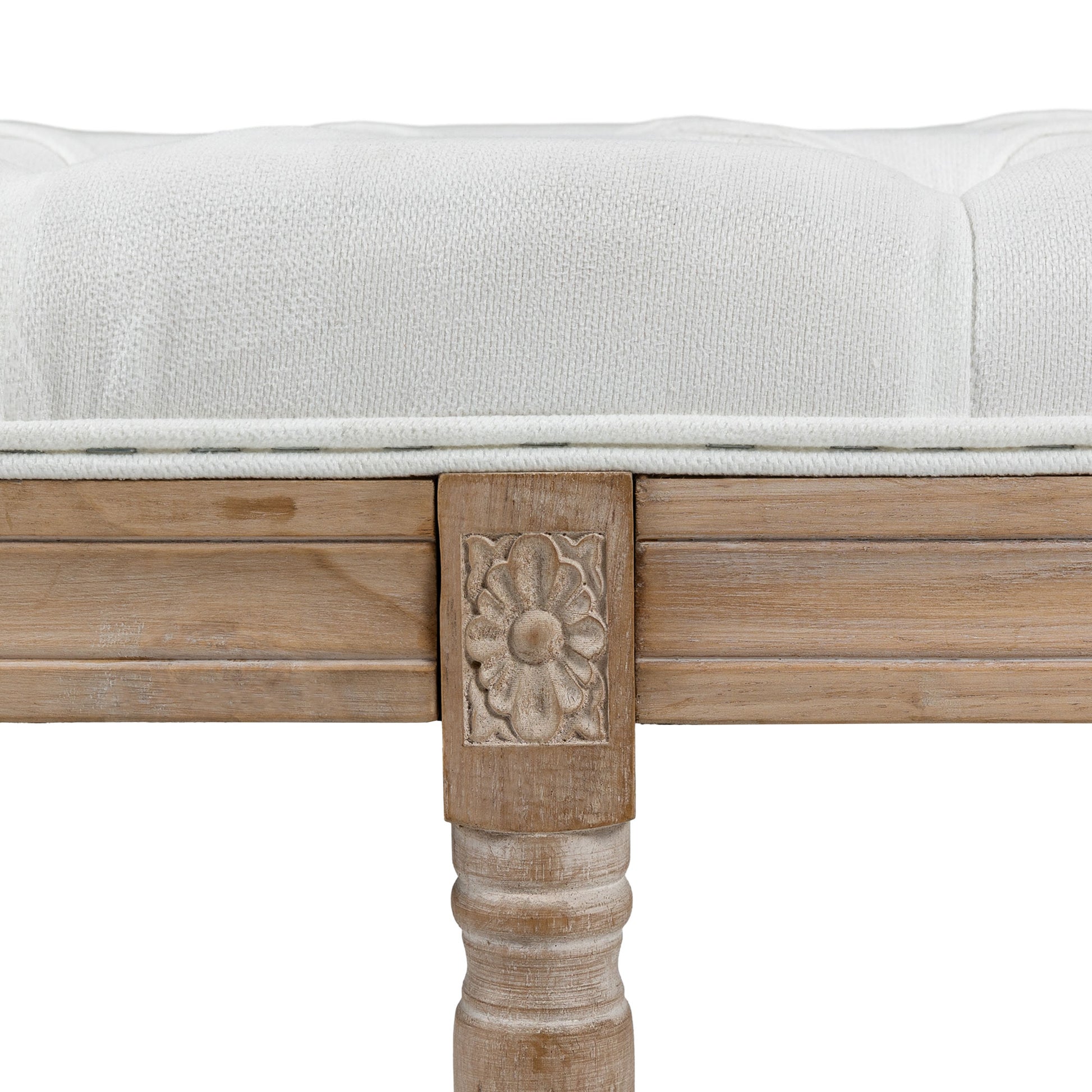 White tufted upholstered bench with carved wood accents