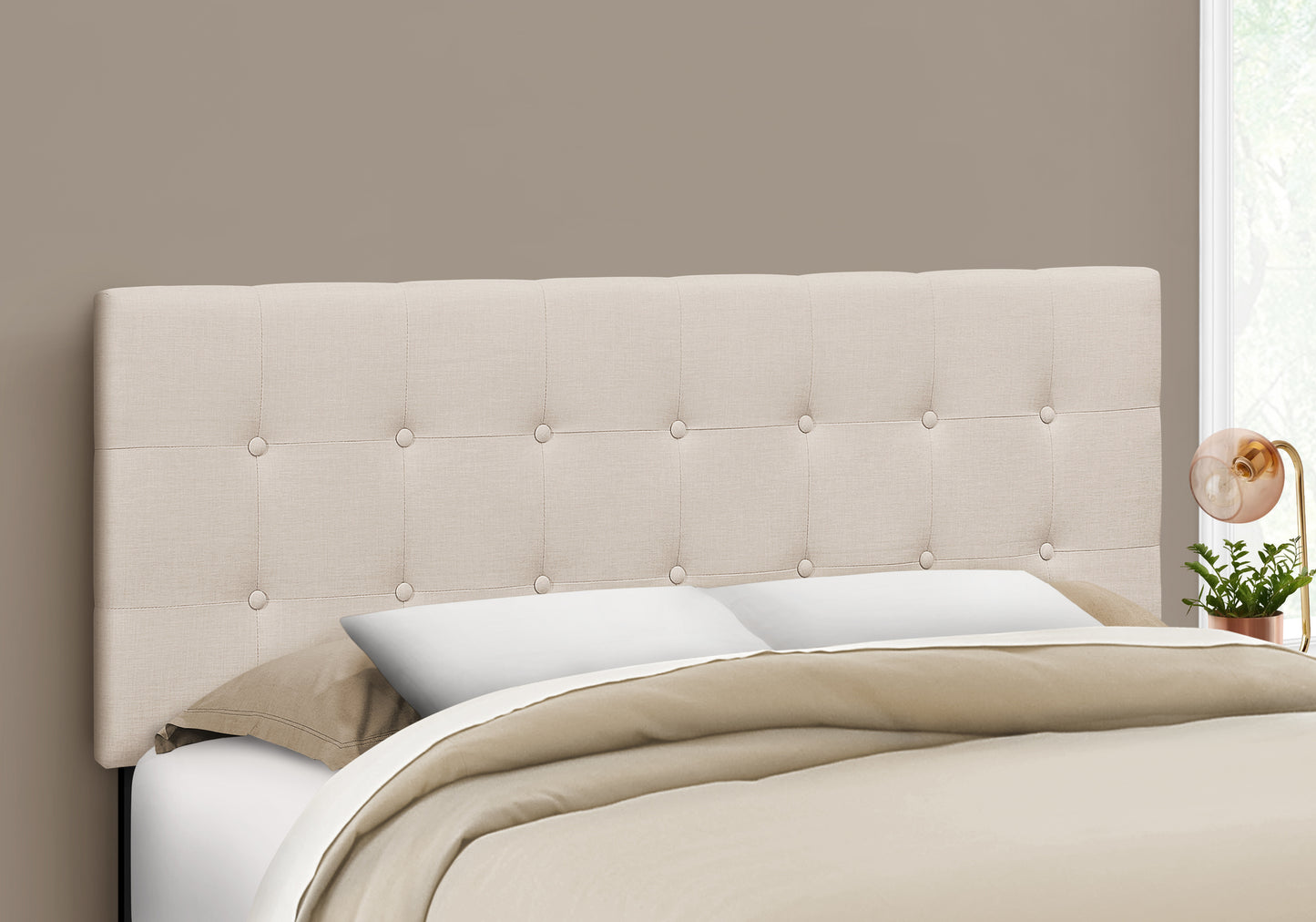 Tufted beige linen headboard with button details adding elegance to a bedroom