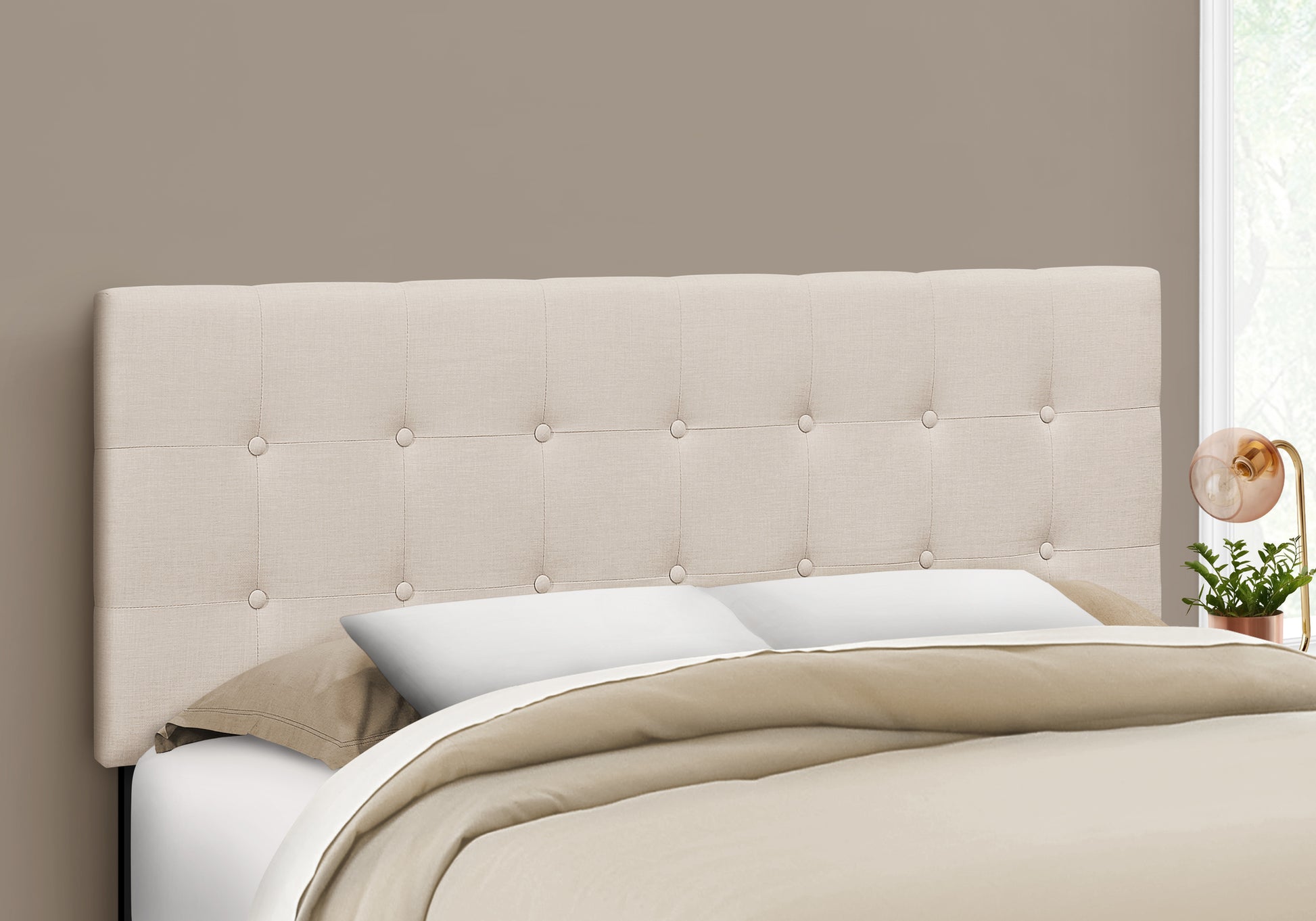 Tufted beige linen headboard with button details adding elegance to a bedroom