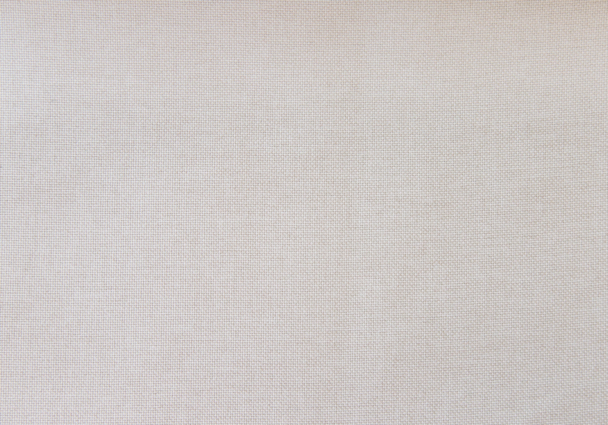 Closeup of a light beige linen fabric texture showing fine weave details