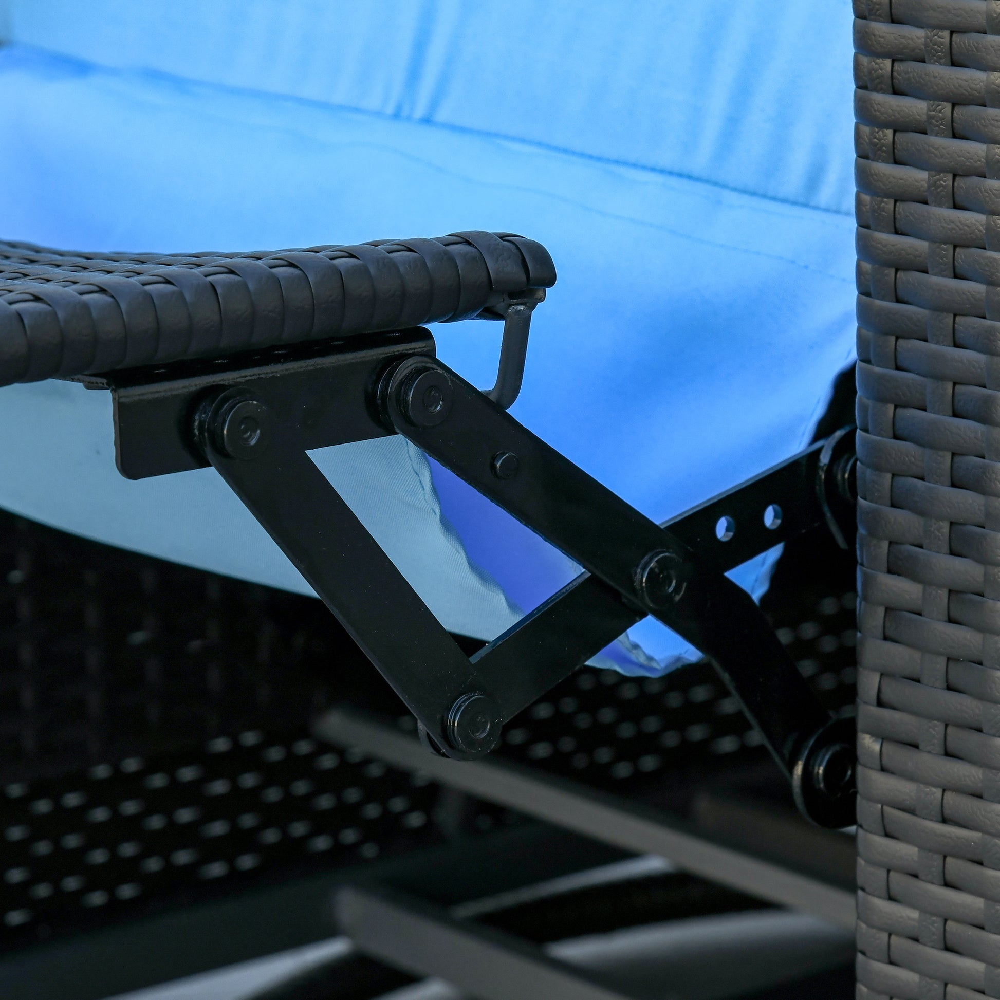 Closeup of black metal reclining mechanism on wicker outdoor chair with blue cushion