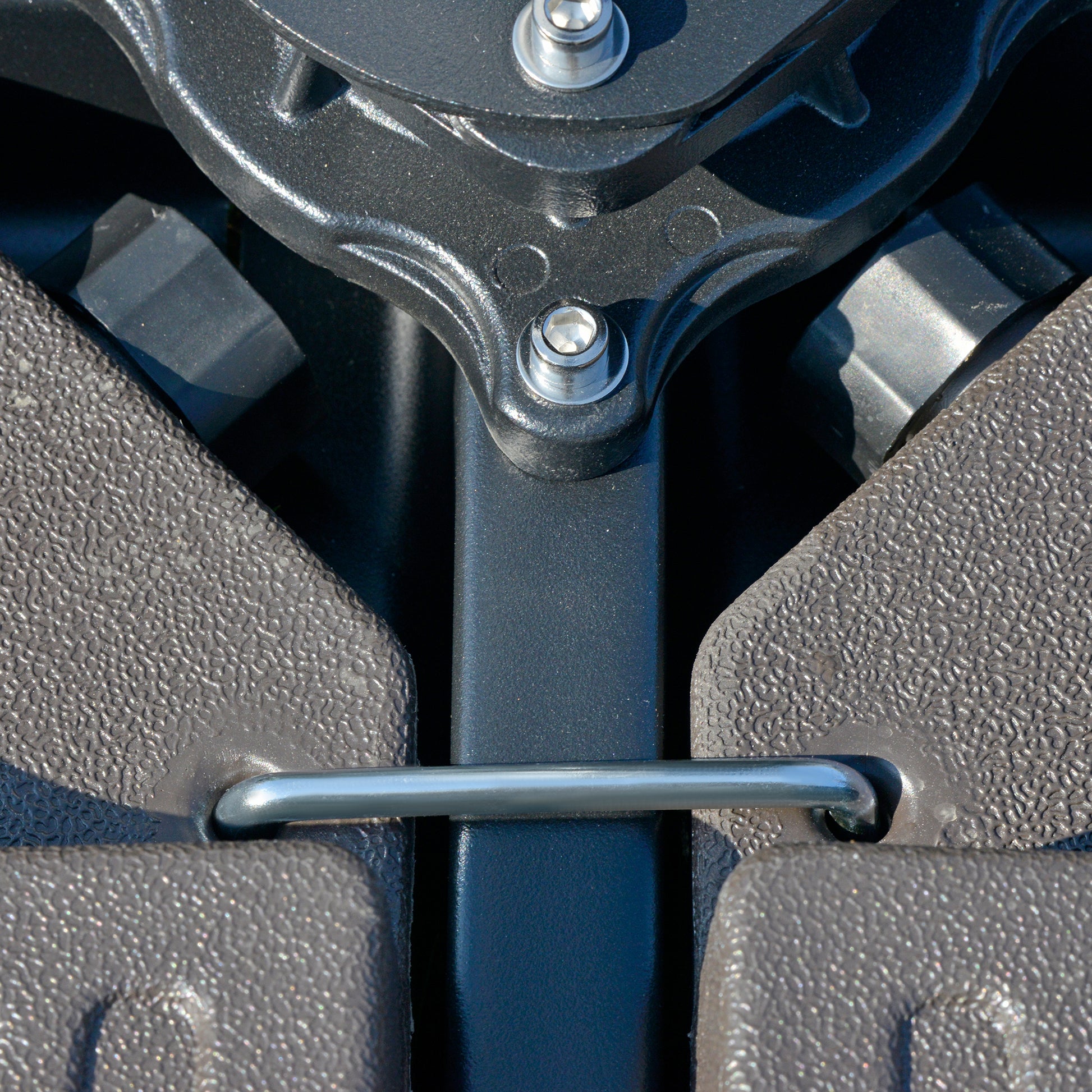 Textured grey plastic parts secured by a black metal bracket and silver bolts