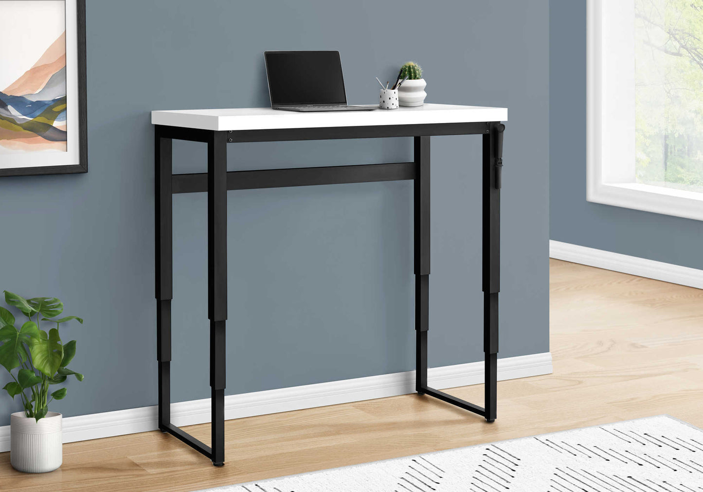 Slim white and black metal console table with laptop and cactus