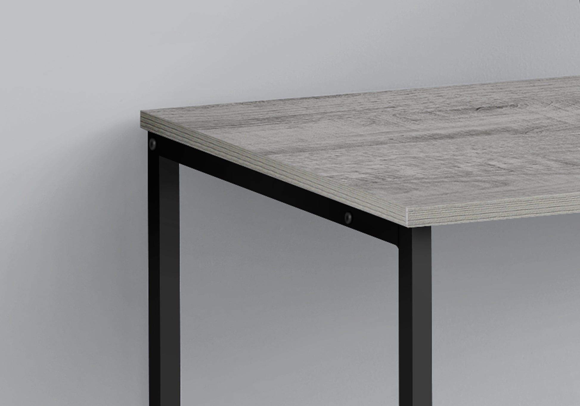 Closeup of a grey wood grain desk with black metal legs
