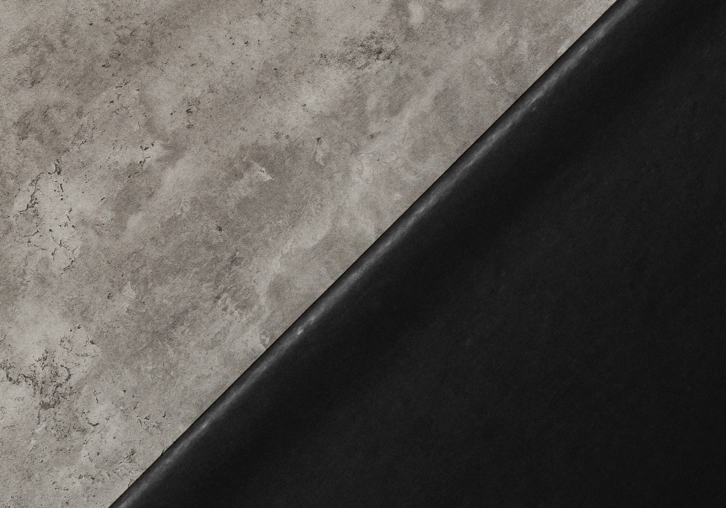 Textured grey concrete surface meeting smooth black leather diagonal split