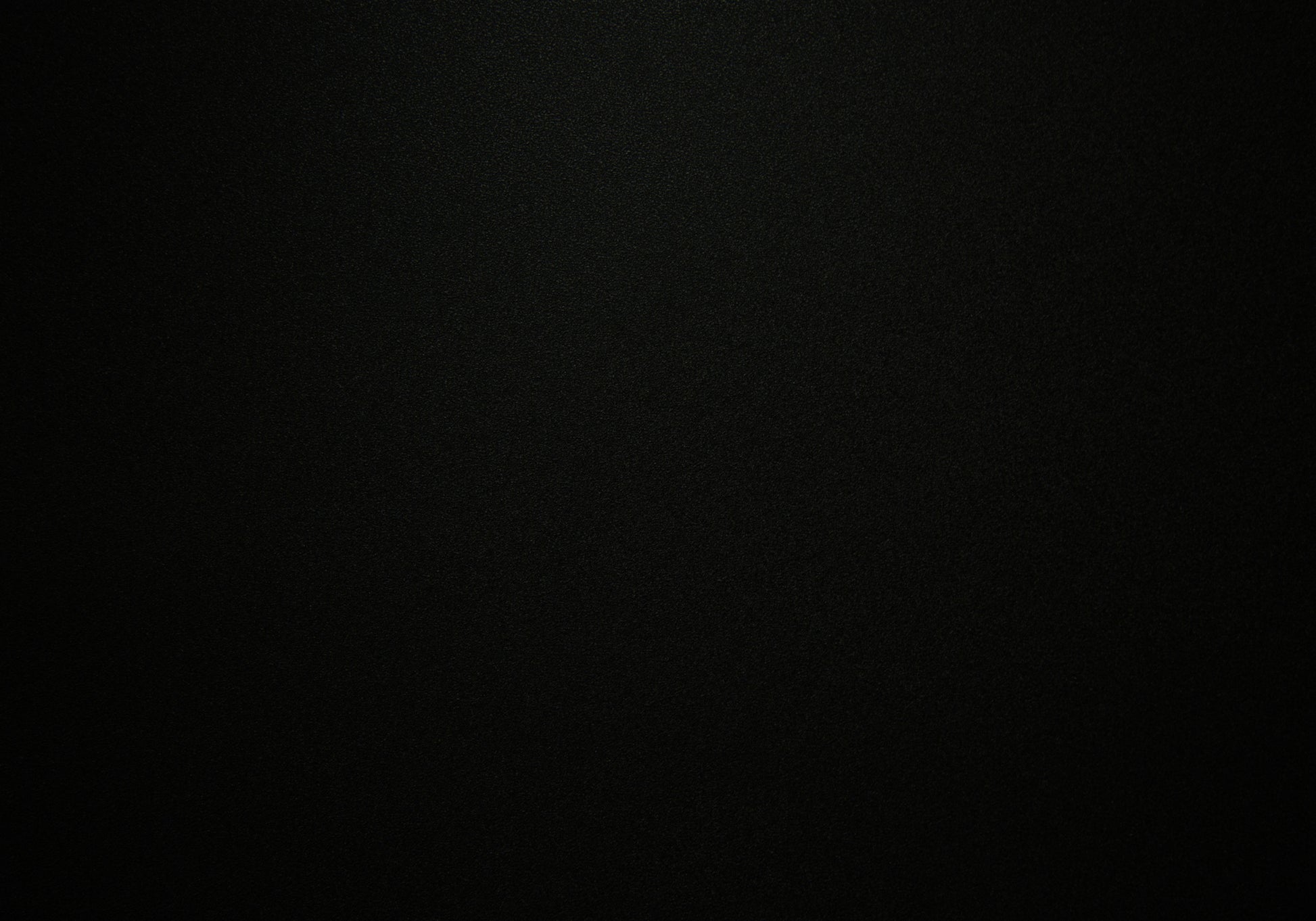 Smooth matte black textured vinyl wallpaper with subtle speckles for a modern accent