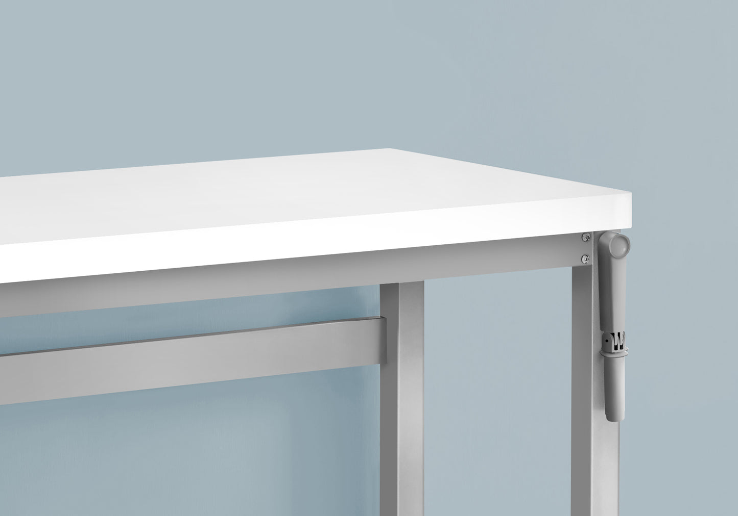 Closeup of a white desktop with a silver metal frame and adjustable height mechanism