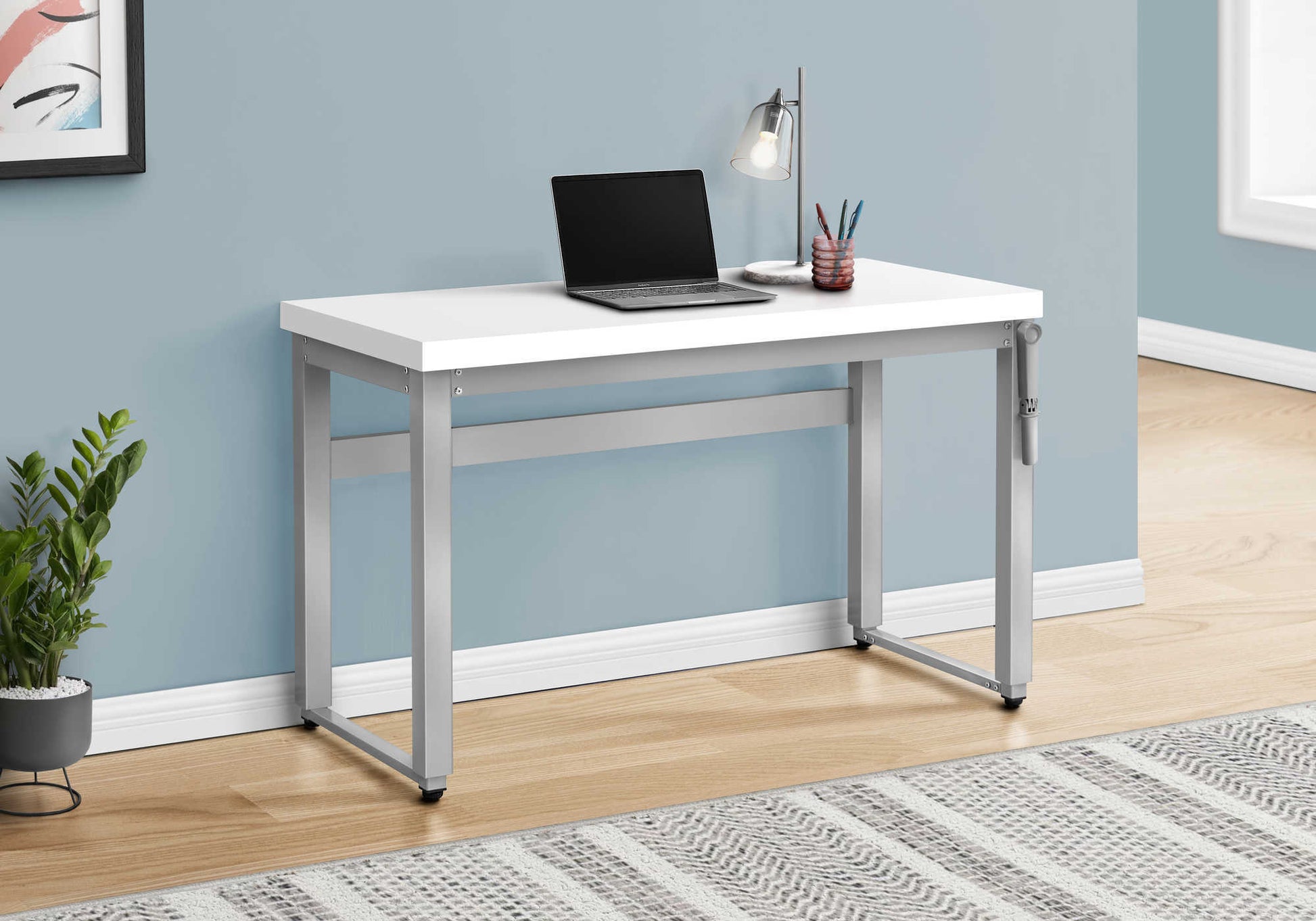 White modern desk with silver metal legs laptop and desk lamp