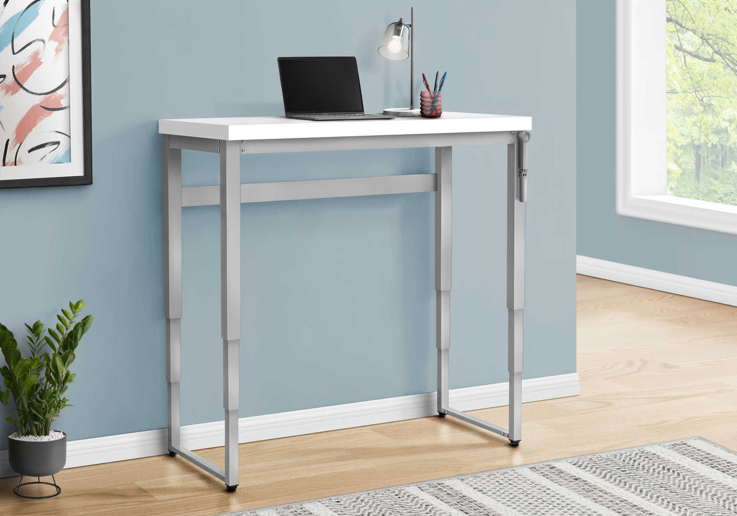 White adjustable standing desk with silver metal legs and laptop