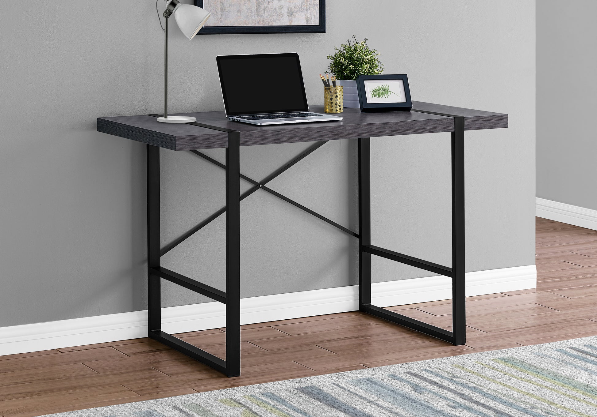 Dark wood grain compact desk with black metal frame laptop and lamp