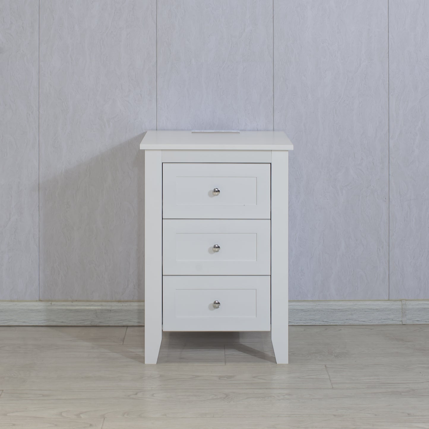 White painted wood nightstand with three drawers and silver knobs