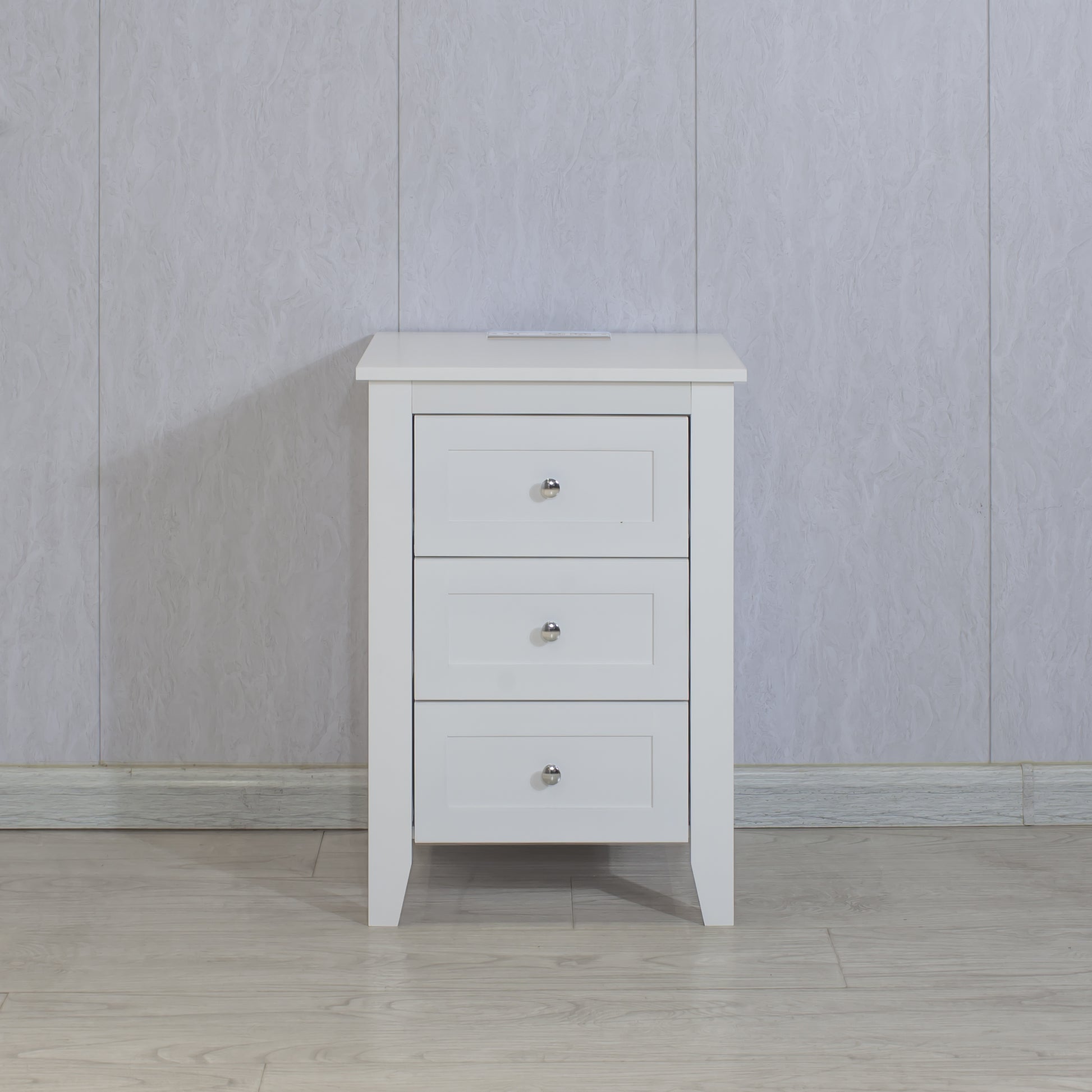 White painted wood nightstand with three drawers and silver knobs