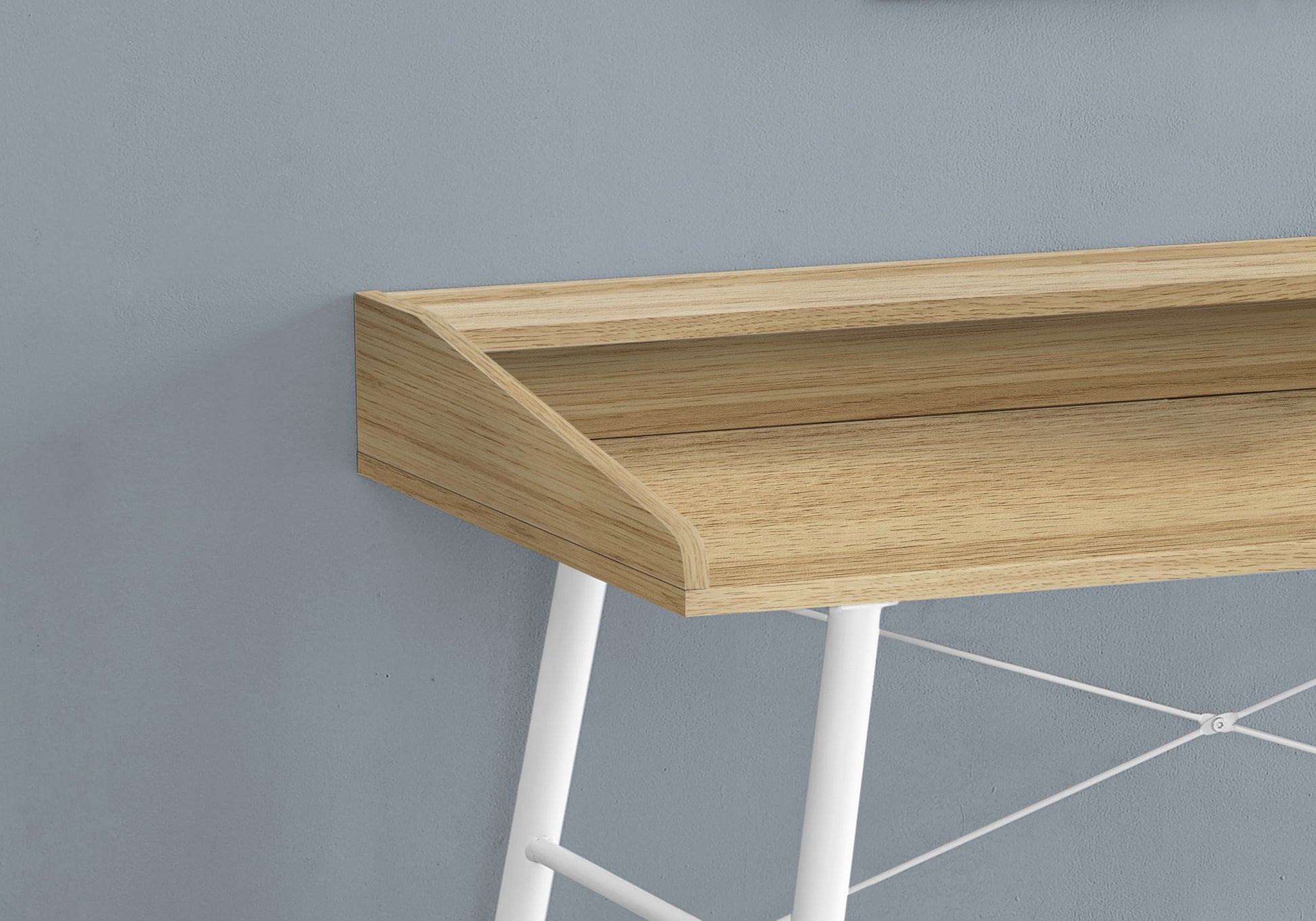 Closeup of a modern woodgrain desk surface with white metal legs and crossbars