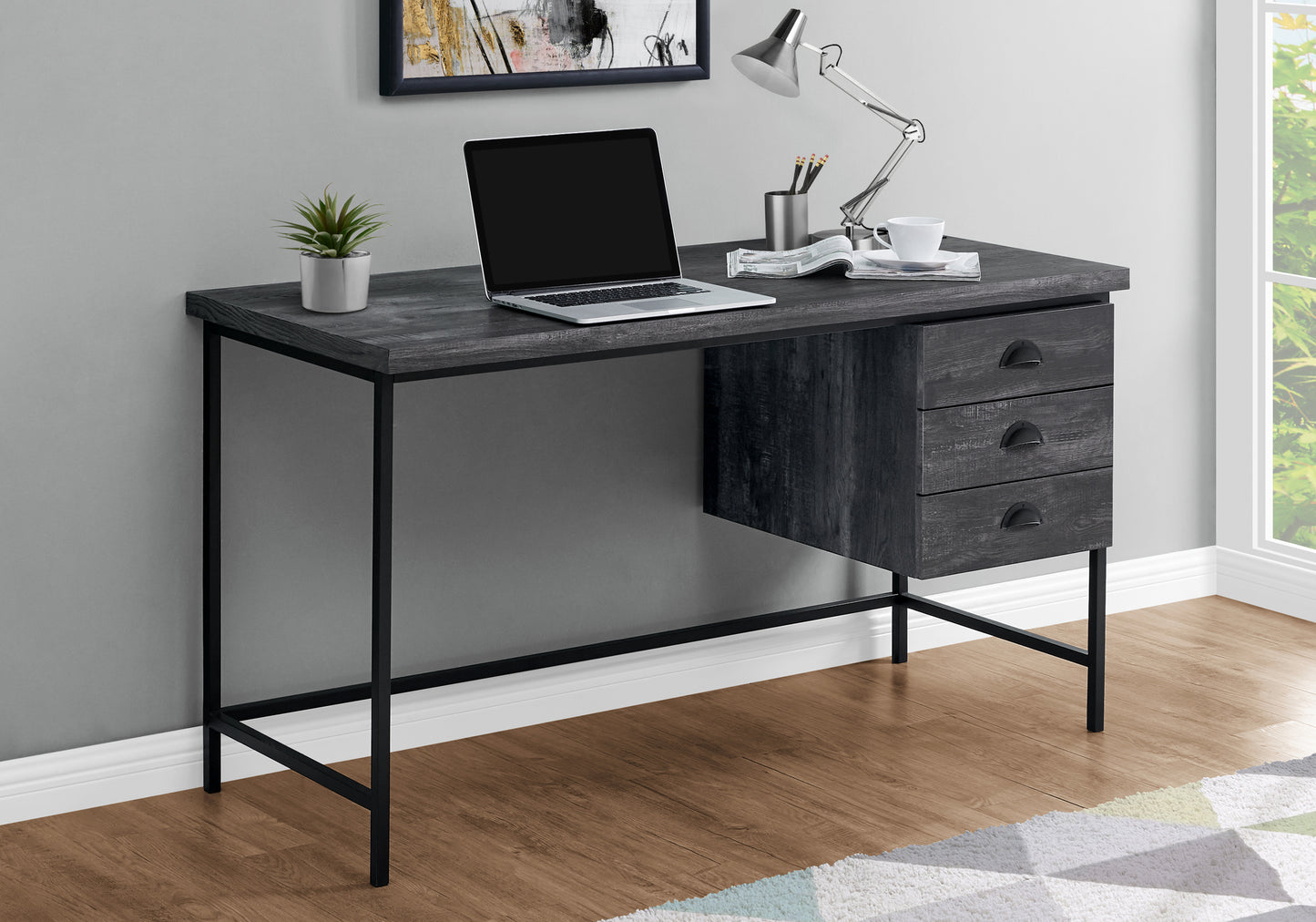 Dark grey wood grain desk with black metal legs and three drawers
