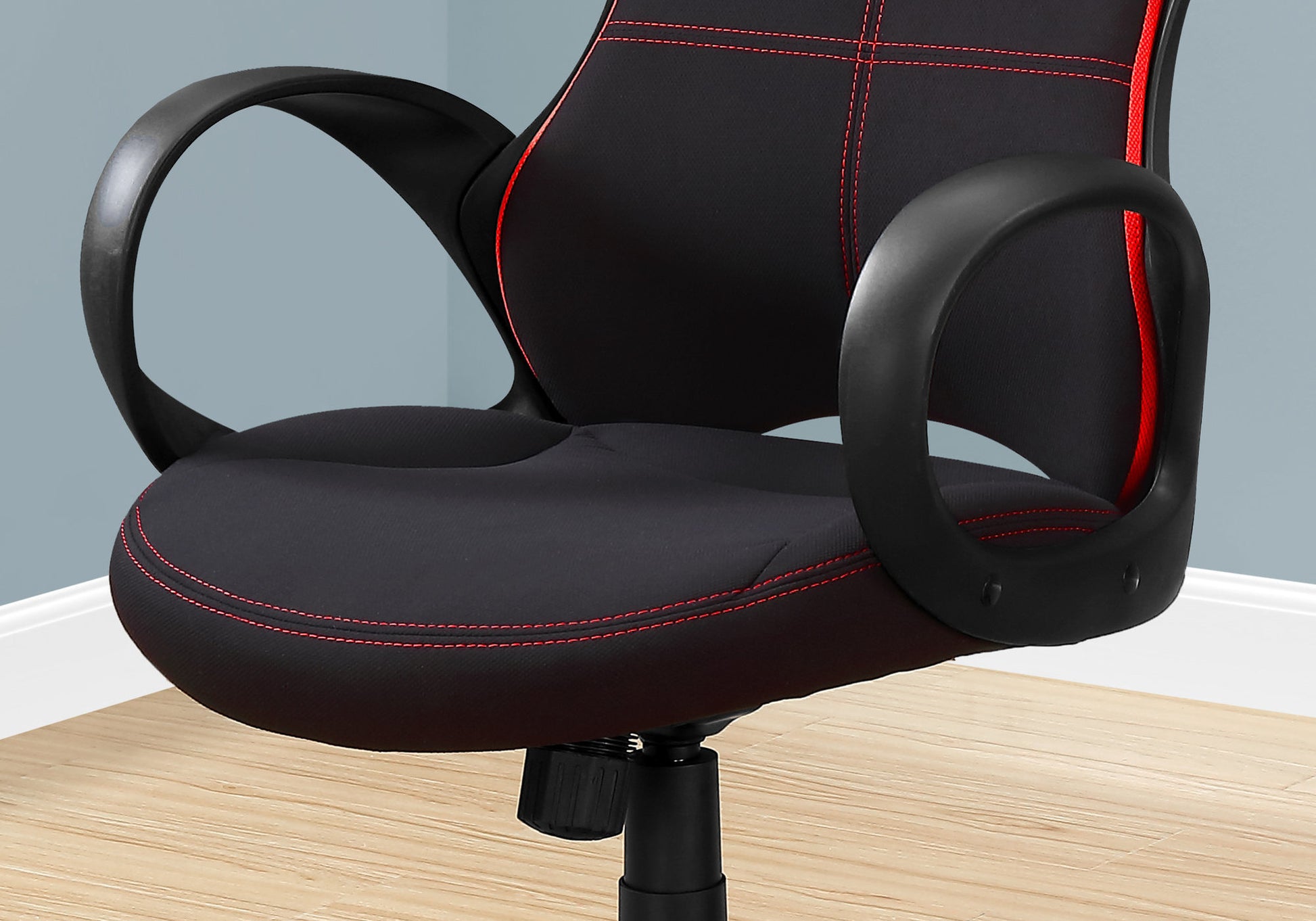 Black office chair with red stitching and padded armrests