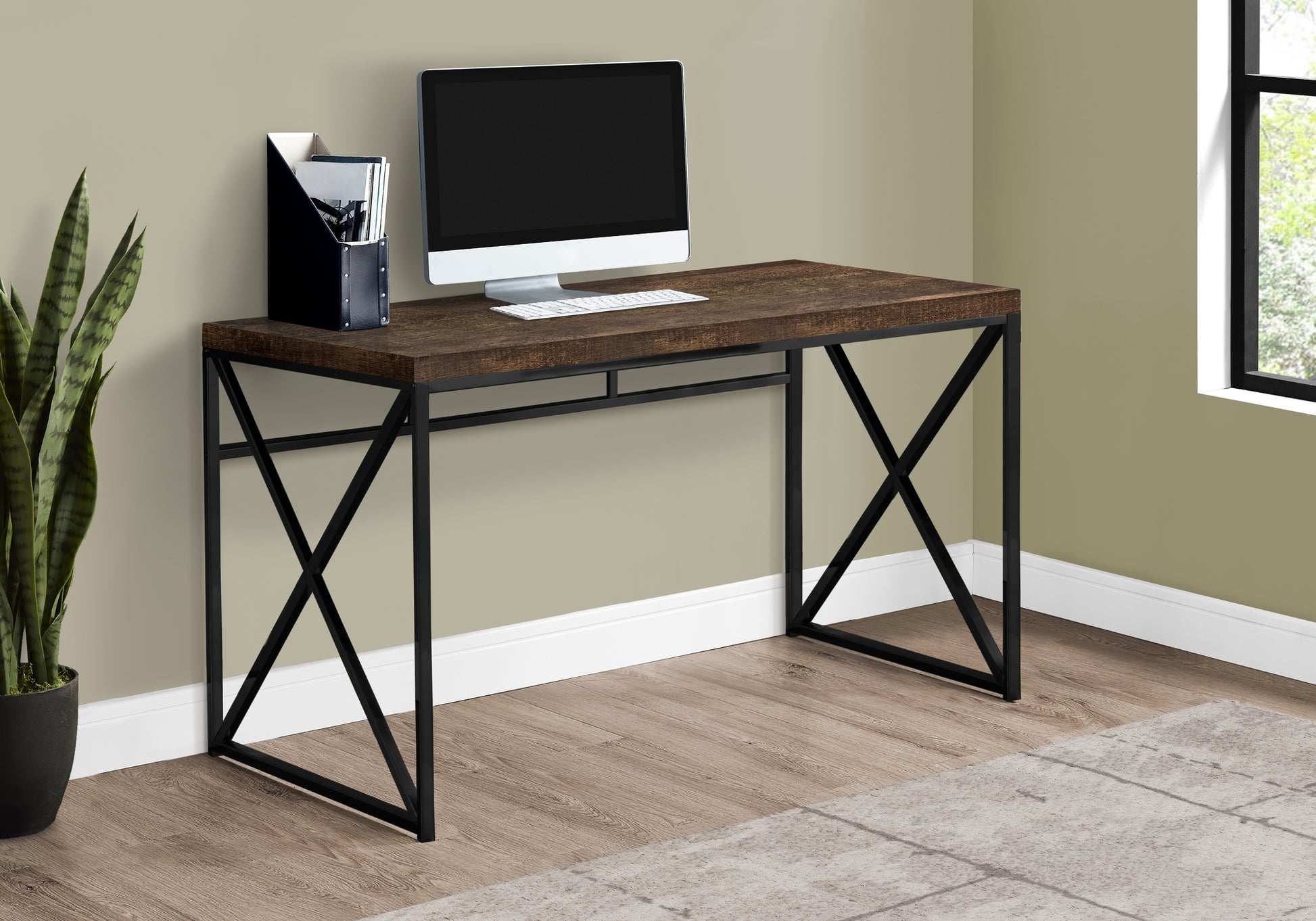 Industrial style dark wood desk with black metal crisscross legs and a computer setup